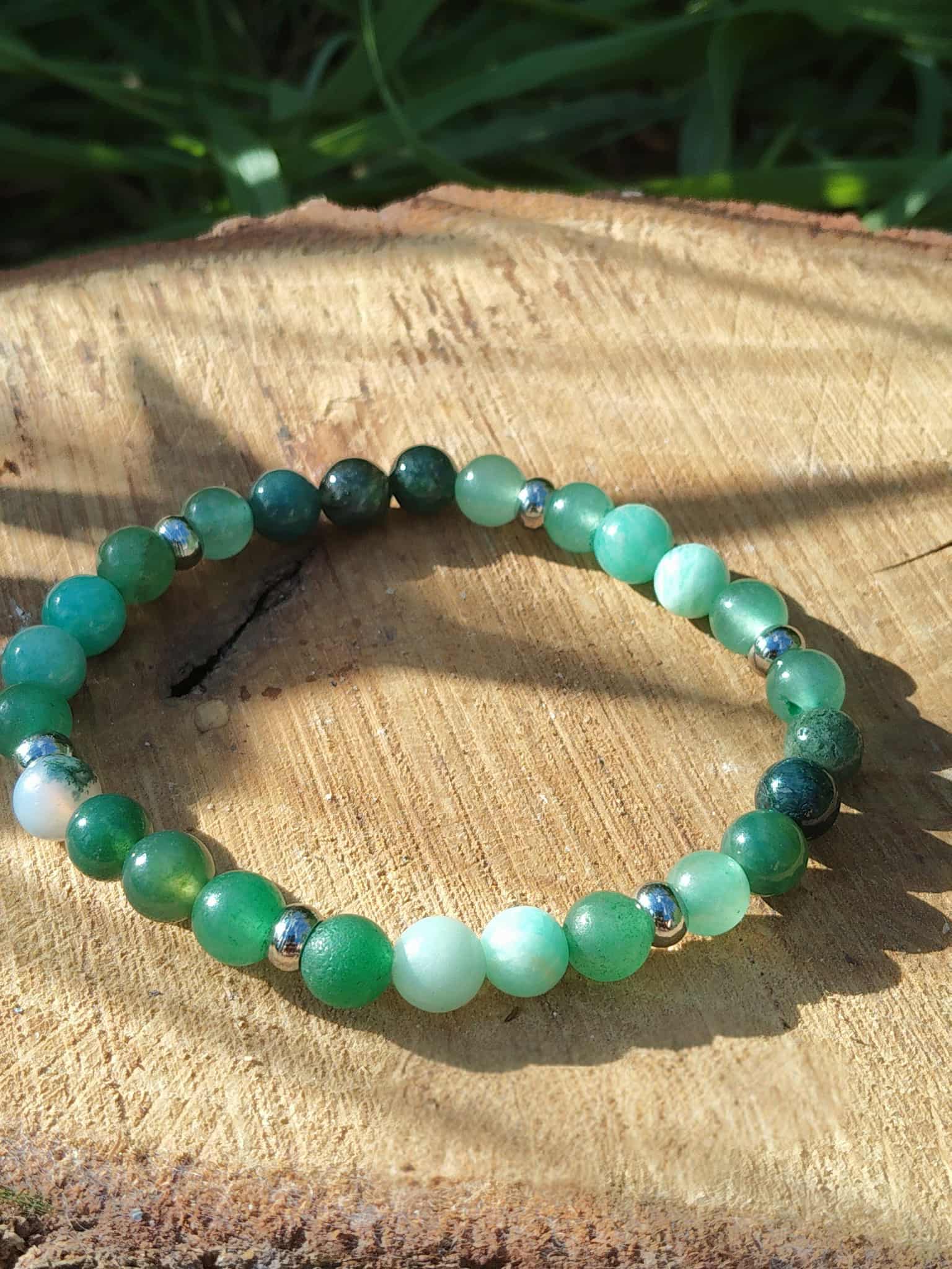 Bracelet Psoriasis 6 mm sur tranche de bois en plein soleil avec herbe en fond, pierres naturelles pour calme du cœur, équilibre et énergie plus douce