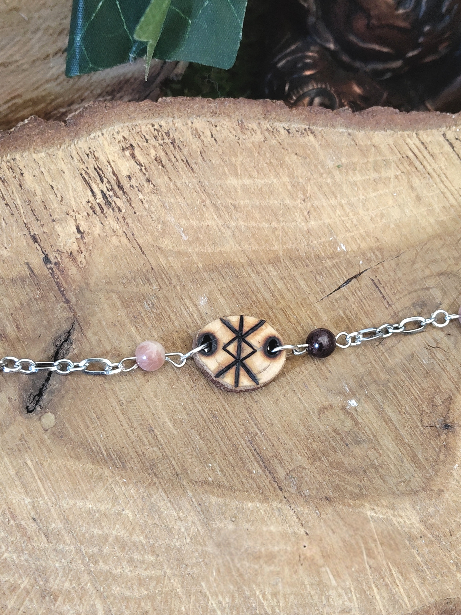 Bracelet rune de protection en bois création Magic Gaïa, chaîne argentée avec perles quartz rose et grenat sur rondin de bois, intention: ancrage et protection symbolique.
