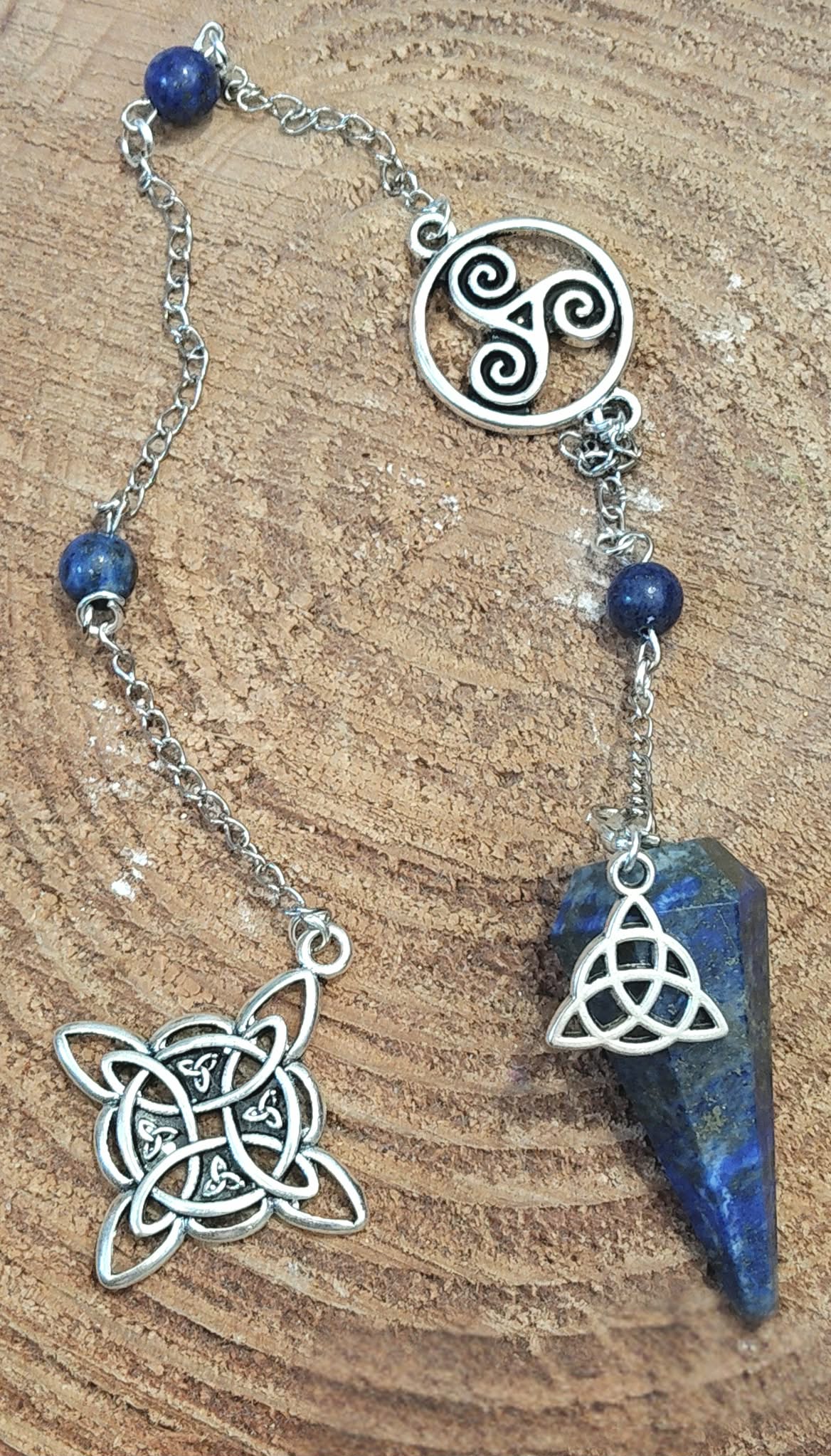 Pendule en lapis-lazuli bleu avec chaîne personnalisée Magic Gaïa, perles assorties et symboles celtiques, présenté sur bois pour une ambiance d’intuition et d’apaisement
