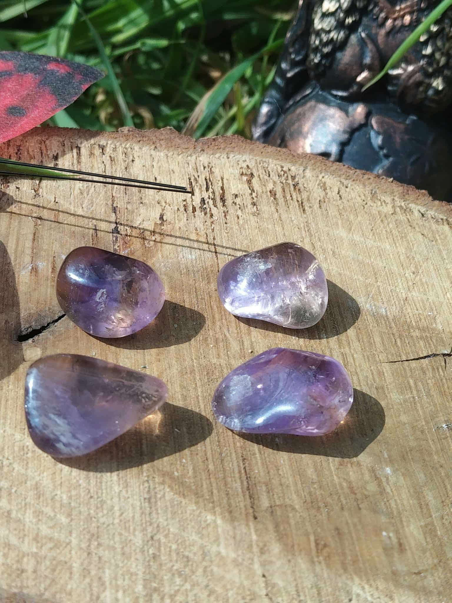 Pierres roulées d’amétrine aux nuances violettes et dorées sur bois, décor feuillage et papillon, pierres naturelles associées à l’inspiration, à la sérénité et à l’équilibre intérieur.