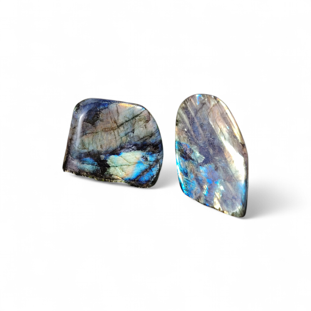 Deux labradorites forme libre aux reflets bleus sur fond blanc, pierres naturelles reliées à la lucidité, à la sérénité et à l’équilibre intérieur.