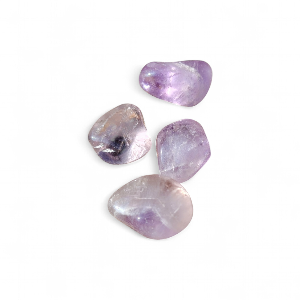 Pierres roulées d’améthyste sur fond blanc épuré, aux nuances violettes douces, évoquant apaisement, intuition et recentrage.