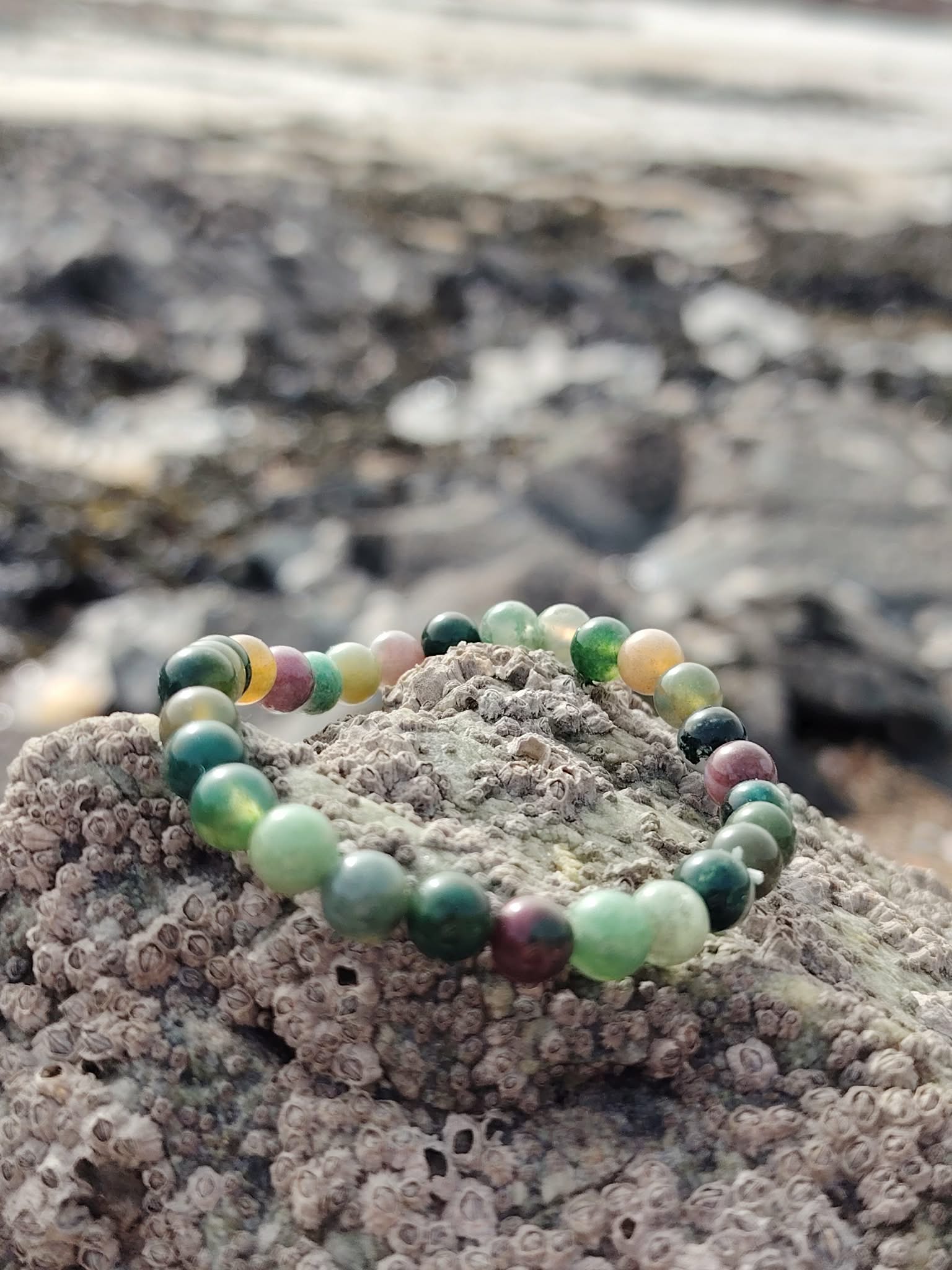 Bracelet Agate Indienne 6 mm sur rocher en bord de mer en Bretagne, perles vertes marbrées, enracinement paisible et équilibre intérieur