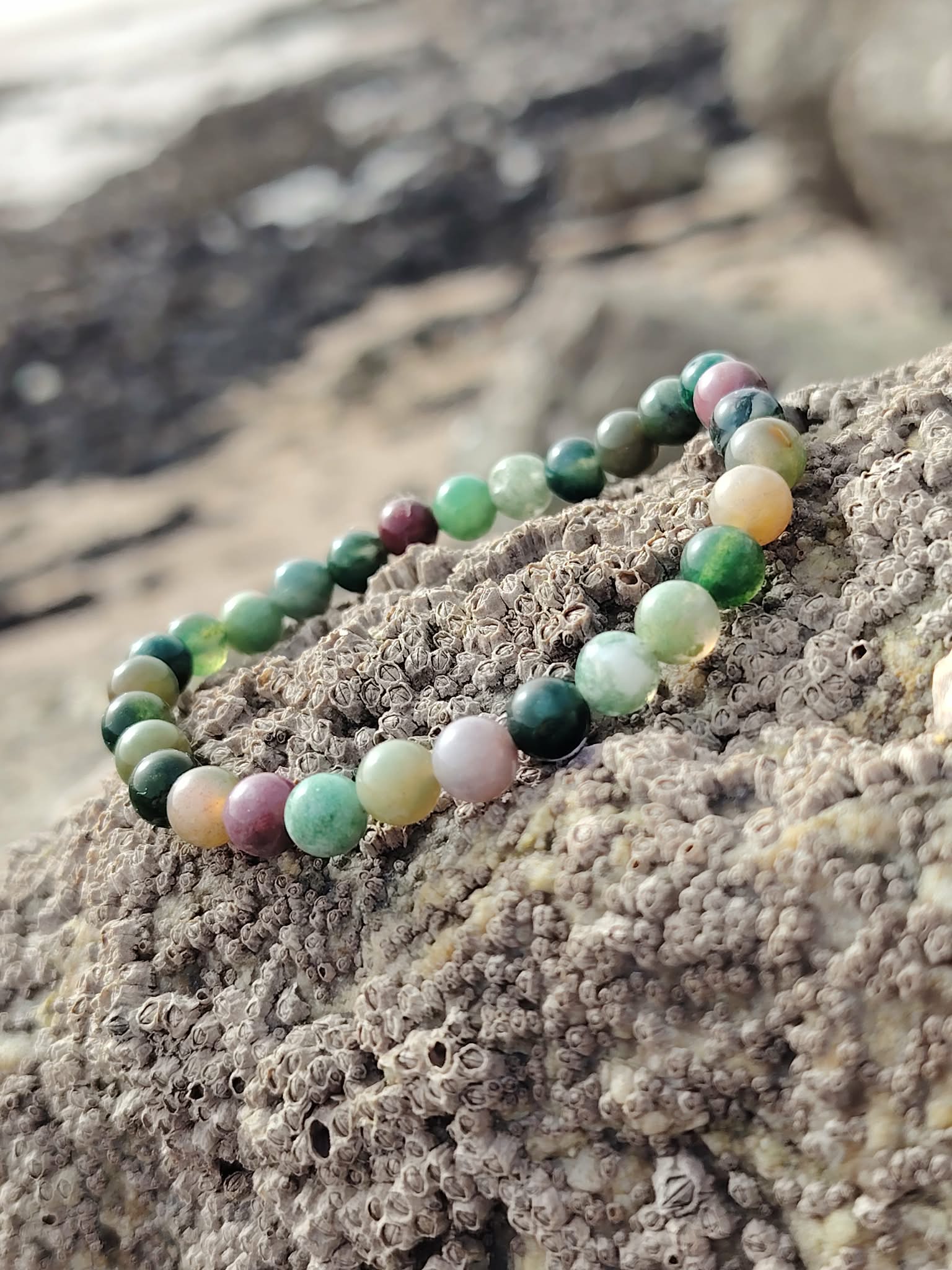 Bracelet Agate Indienne 6 mm étiré sur rocher granitique en Bretagne, perles vert sauge et tons terre, ancrage souple et esprit posé