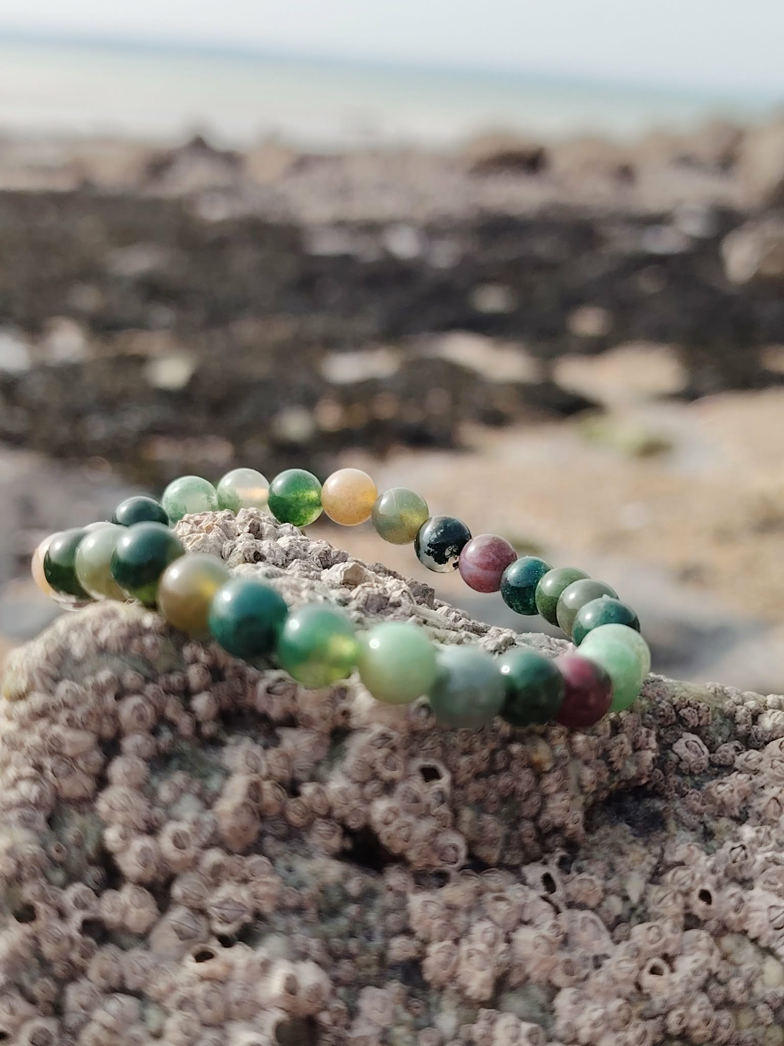 Bracelet Agate Indienne 6 mm sur rocher granuleux en Bretagne, perles vert mousse et tons sable, apaisement mental et retour à soi