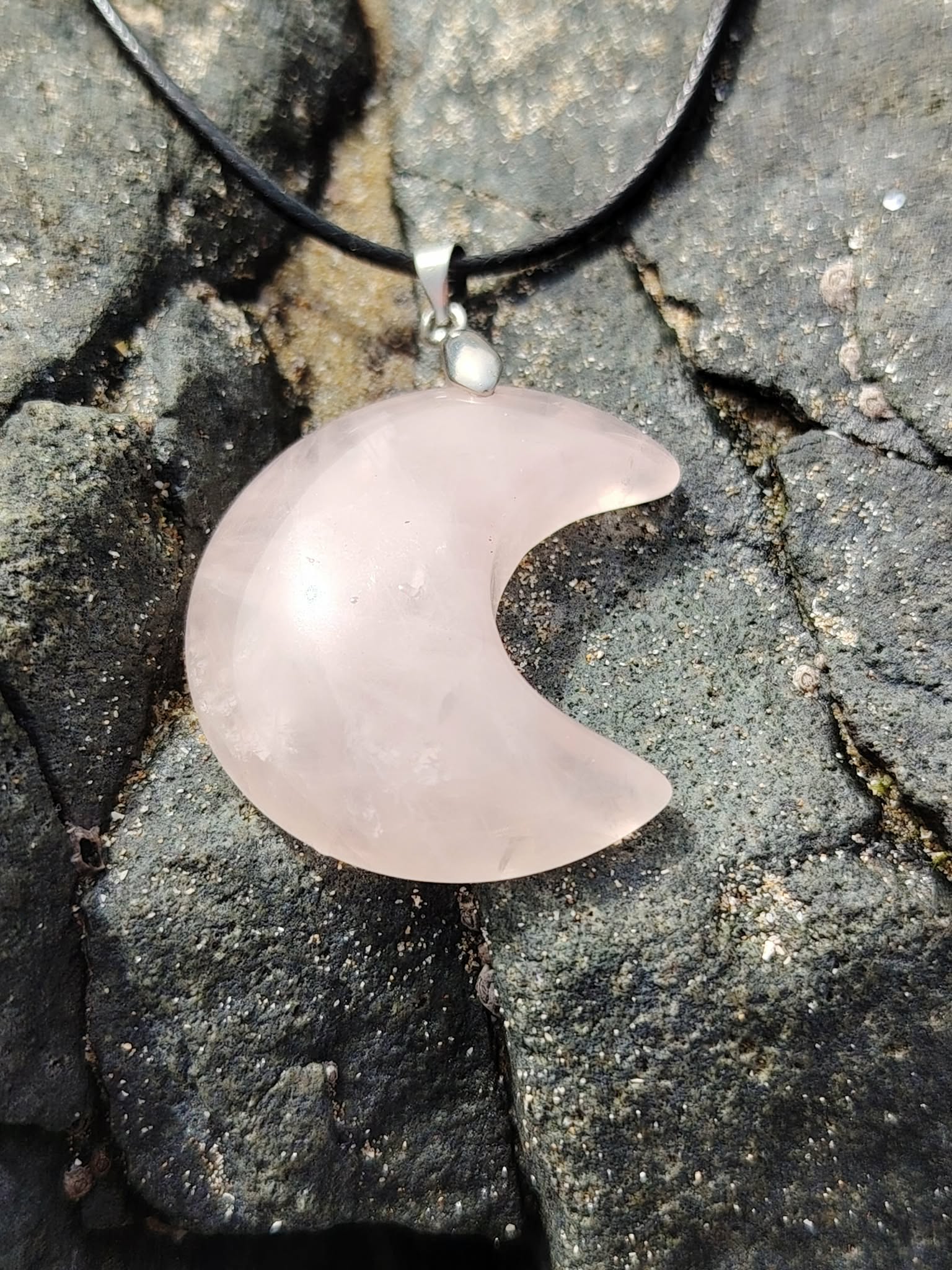Pendentif lune en quartz rose naturel sur roche en Bretagne, bijou doux et lumineux relié à l’amour de soi, à la consolation et à l’harmonie intérieure.
