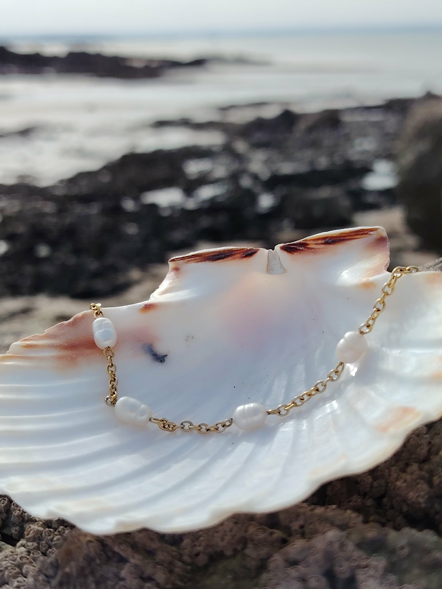 Bracelet perles d’eau douce et nacre sur coquillage blanc en Bretagne face à la mer, douceur, harmonie et élégance