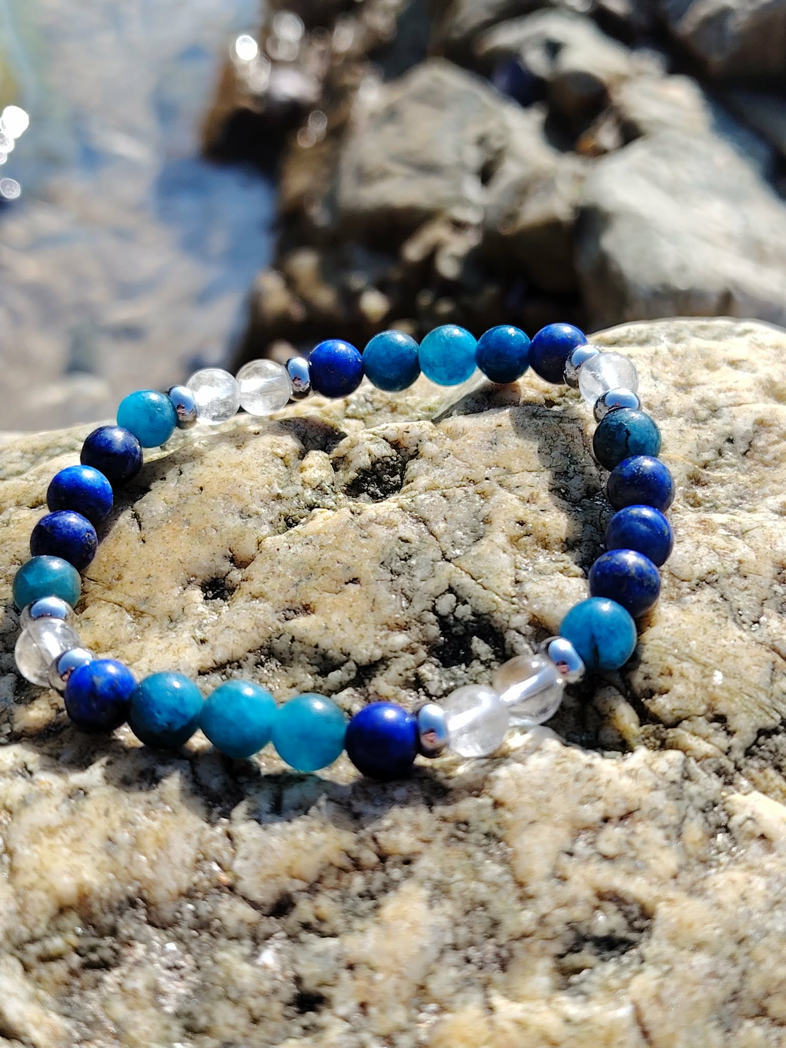 Bracelet Creativity Boost 6 mm en lapis-lazuli, apatite et cristal de roche sur rochers bretons, inspiration claire, imagination vive et énergie de création