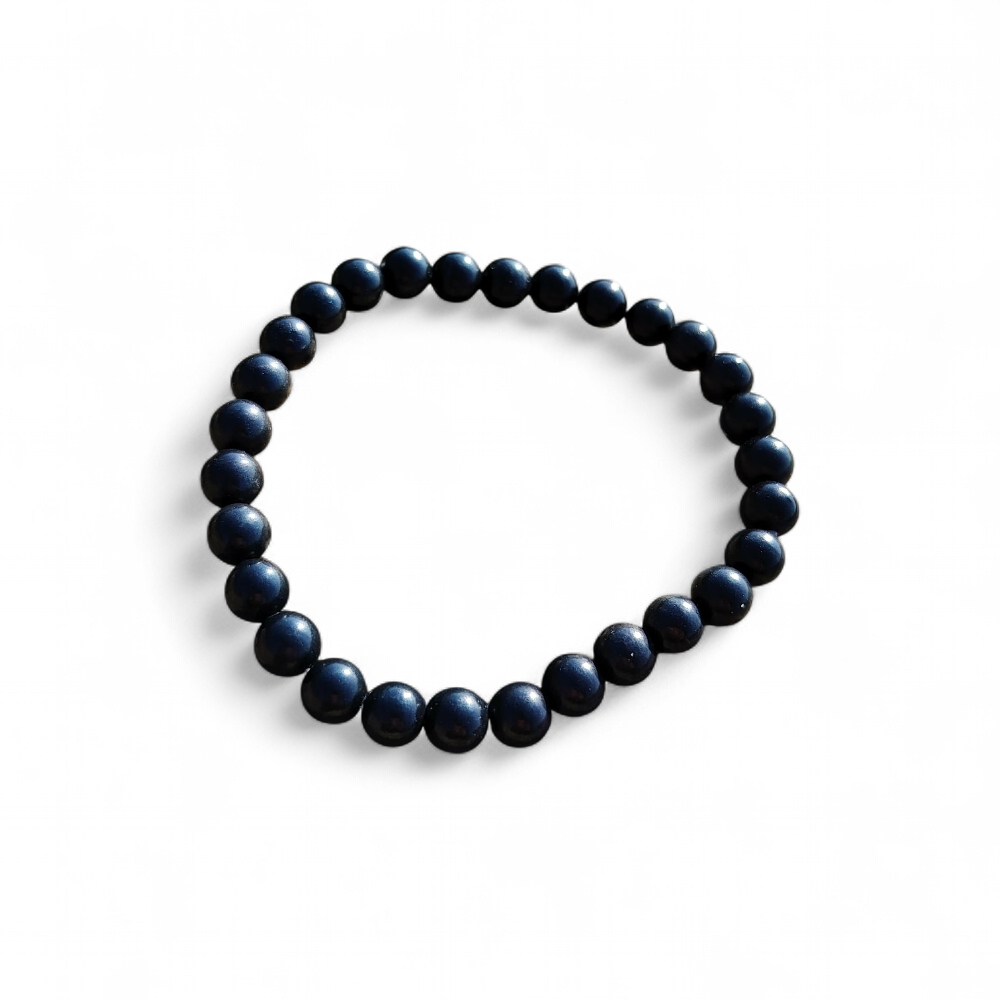 Bracelet shungite 6 mm sur fond blanc, perles noires polies en pierre naturelle pour recentrage, tenue émotionnelle et force tranquille