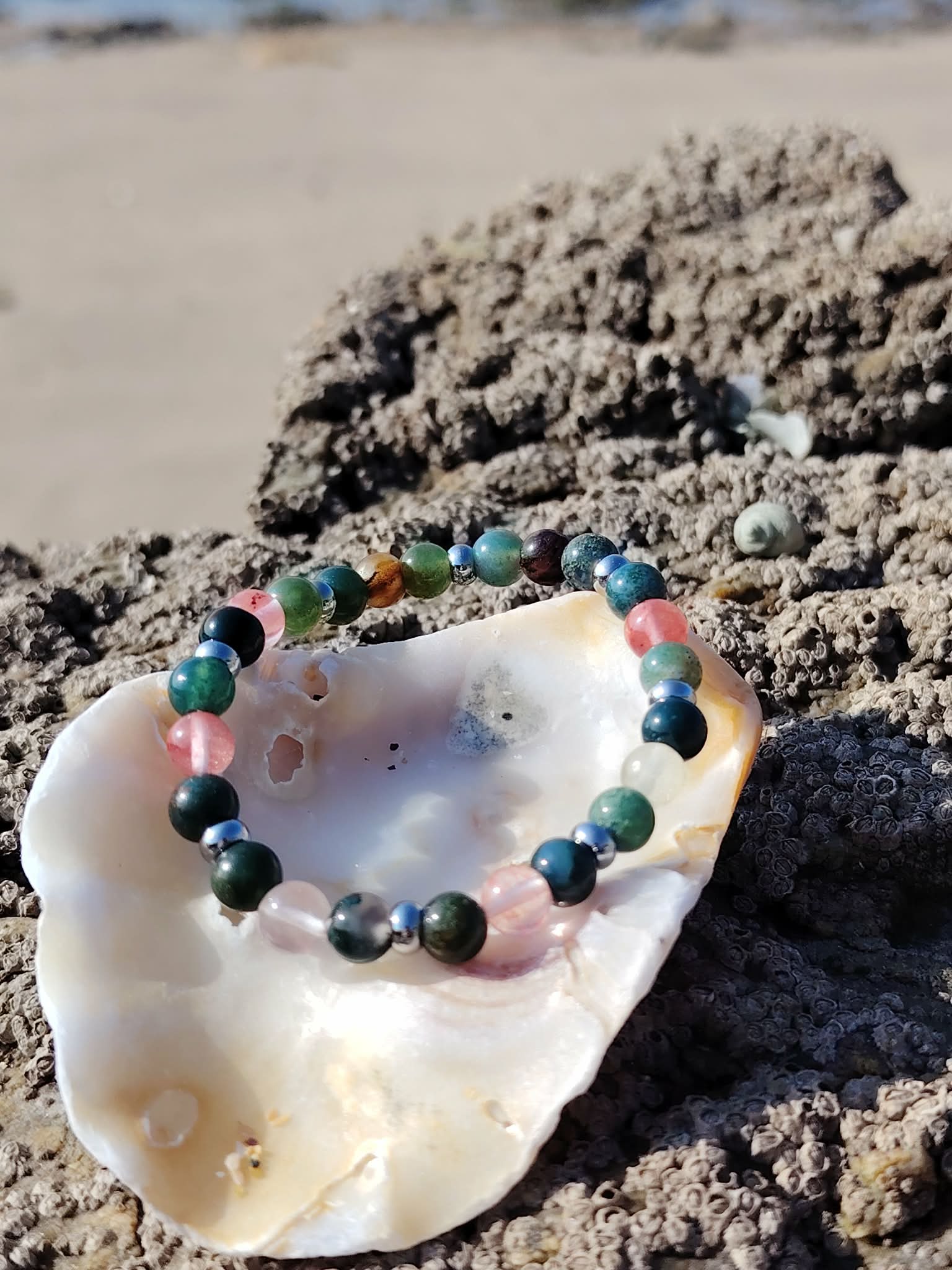 Bracelet chakra cœur 6 mm dans un coquillage sur rochers en Bretagne, pierre naturelle pour équilibre affectif, douceur du lien et sérénité émotionnelle
