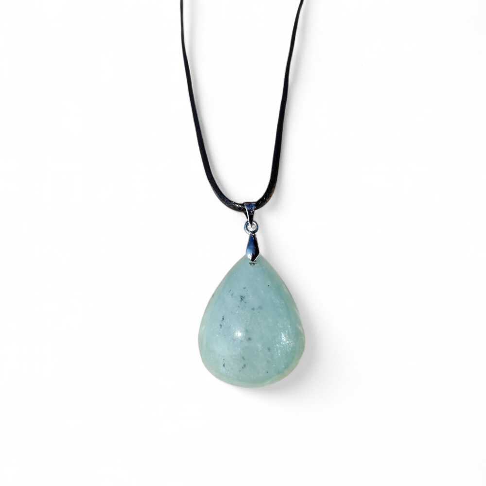 Pendentif en aigue-marine sur cordon noir, présenté sur fond blanc, pierre naturelle reliée à la parole apaisée, au calme du cœur et à la clarté d’esprit.