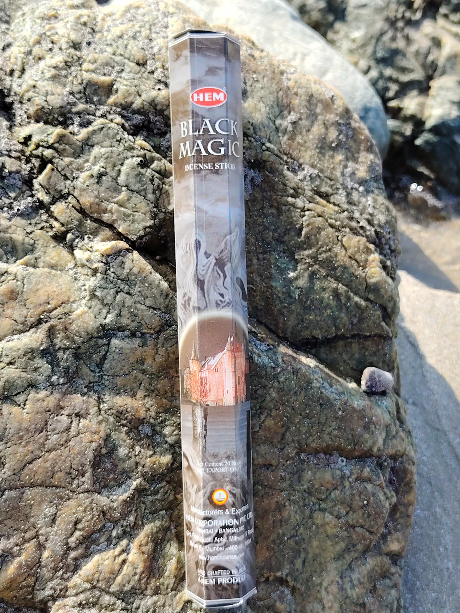 Encens magie noire posé sur roche au bord de l’eau, ambiance mystique, protection symbolique, ancrage et purification, photo Bretagne