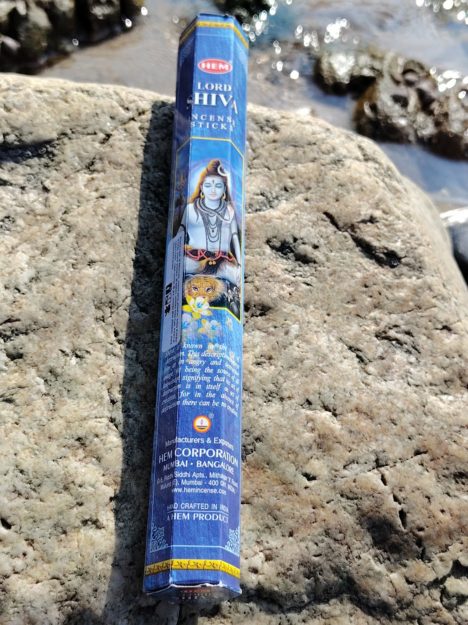 Encens Shiva posé sur les rochers en Bretagne face à l’océan, photo spirituelle évoquant purification, élévation et énergie sacrée.