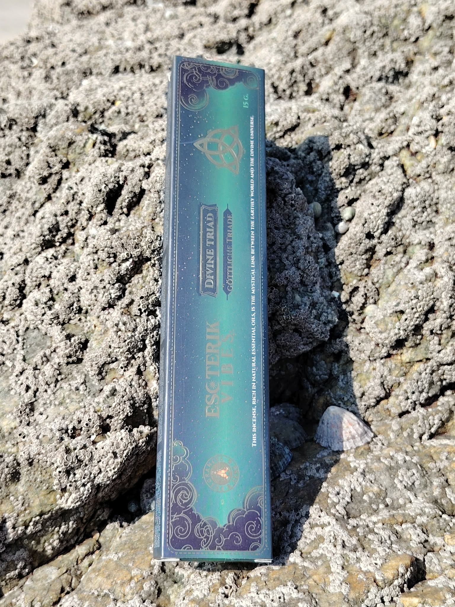 Boîte d’encens Esoteric Vibes Triquetra posée sur les rochers en Bretagne, dans une ambiance minérale et spirituelle évoquant harmonie, protection et recentrage
