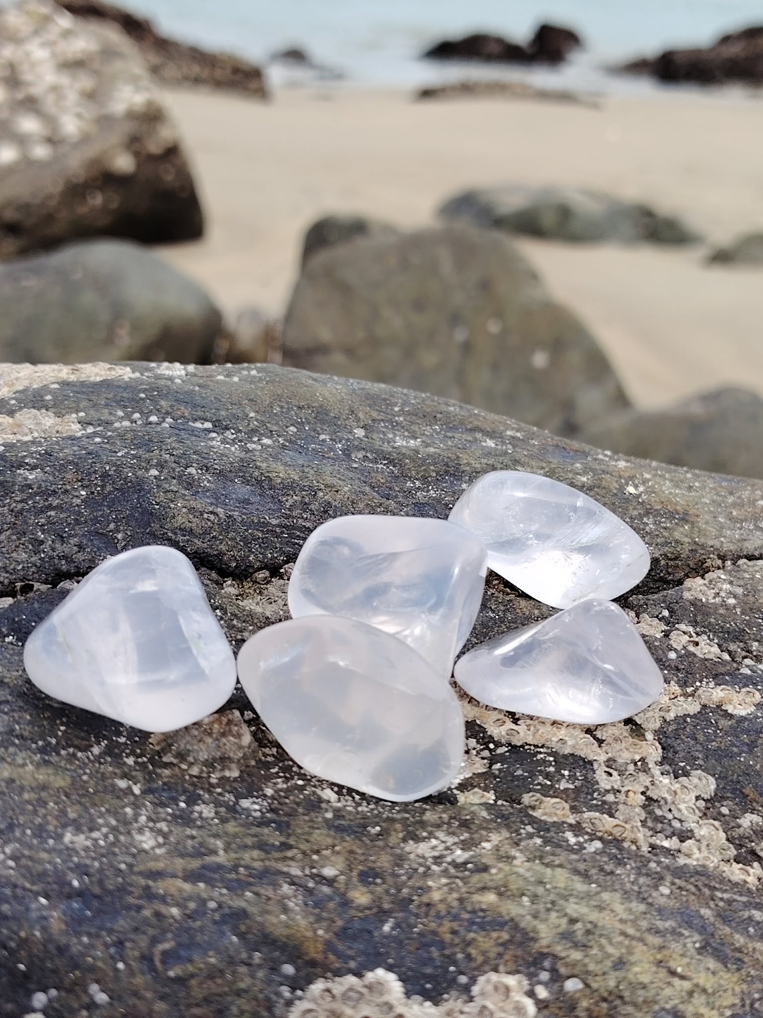 Cristal de roche en pierre roulée sur décor sobre, quartz transparent symbole de lumière, équilibre et clarté d’esprit.
