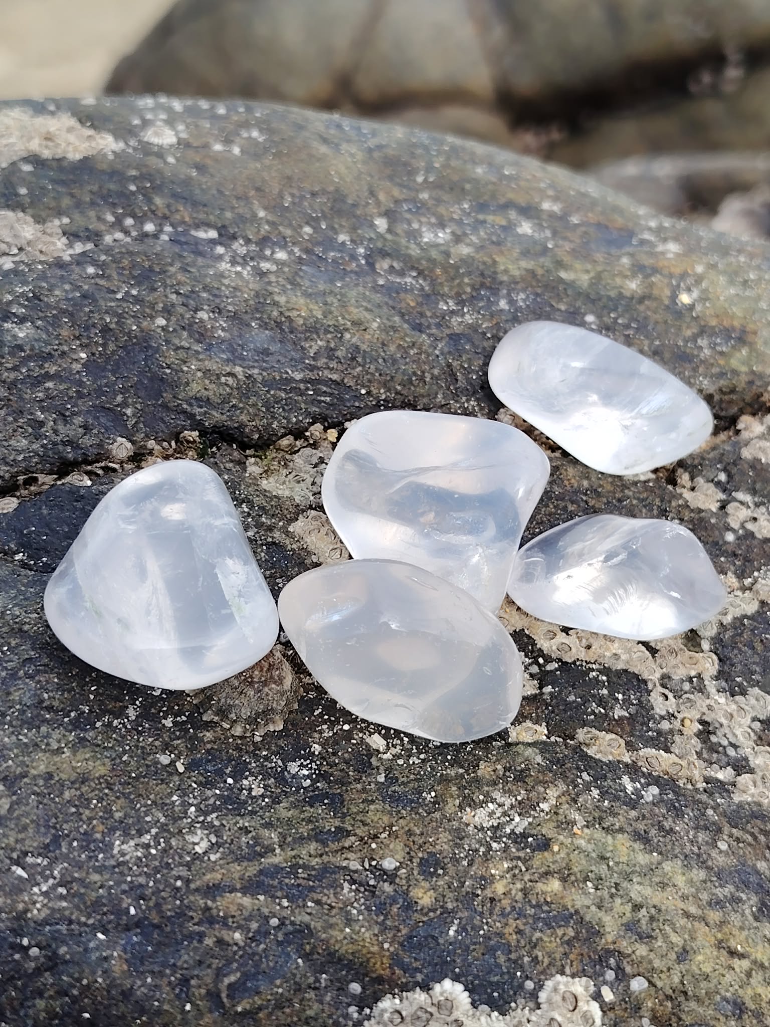 Pierre roulée en cristal de roche en gros plan, quartz clair et lumineux, purification énergétique et harmonie intérieure.