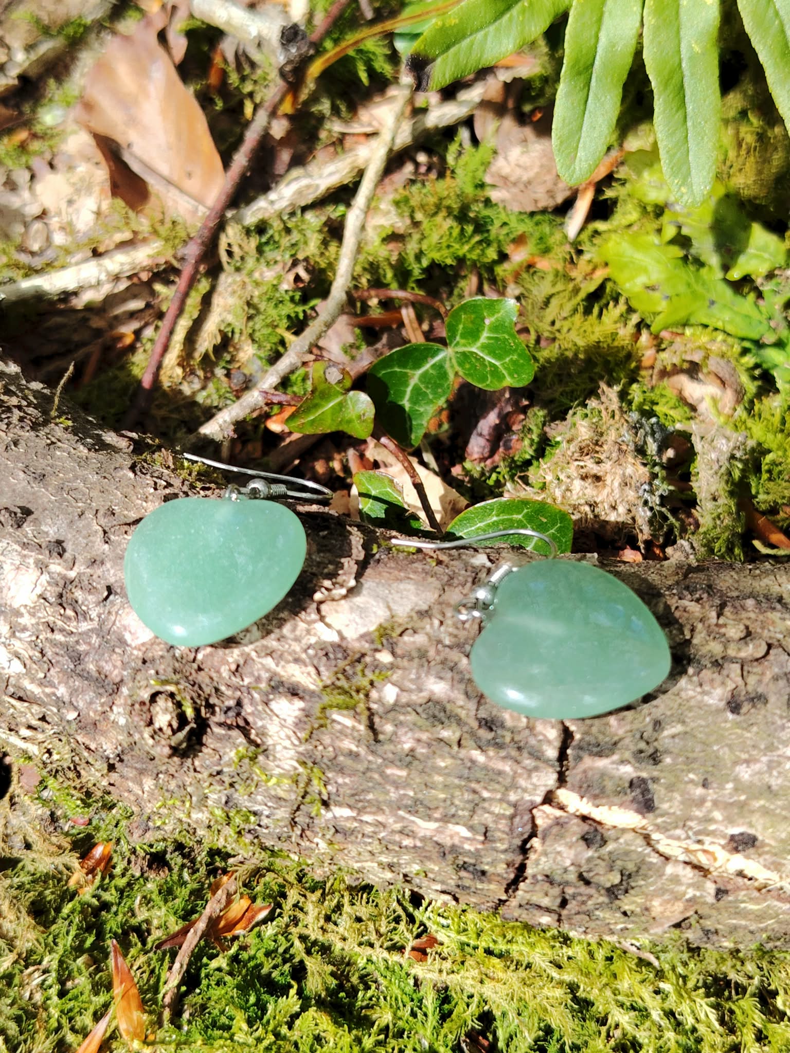 Boucles d’oreilles cœur aventurine verte sur fond clair, bijou délicat en pierre naturelle relié à la tendresse, au calme émotionnel et à l’équilibre intérieur.