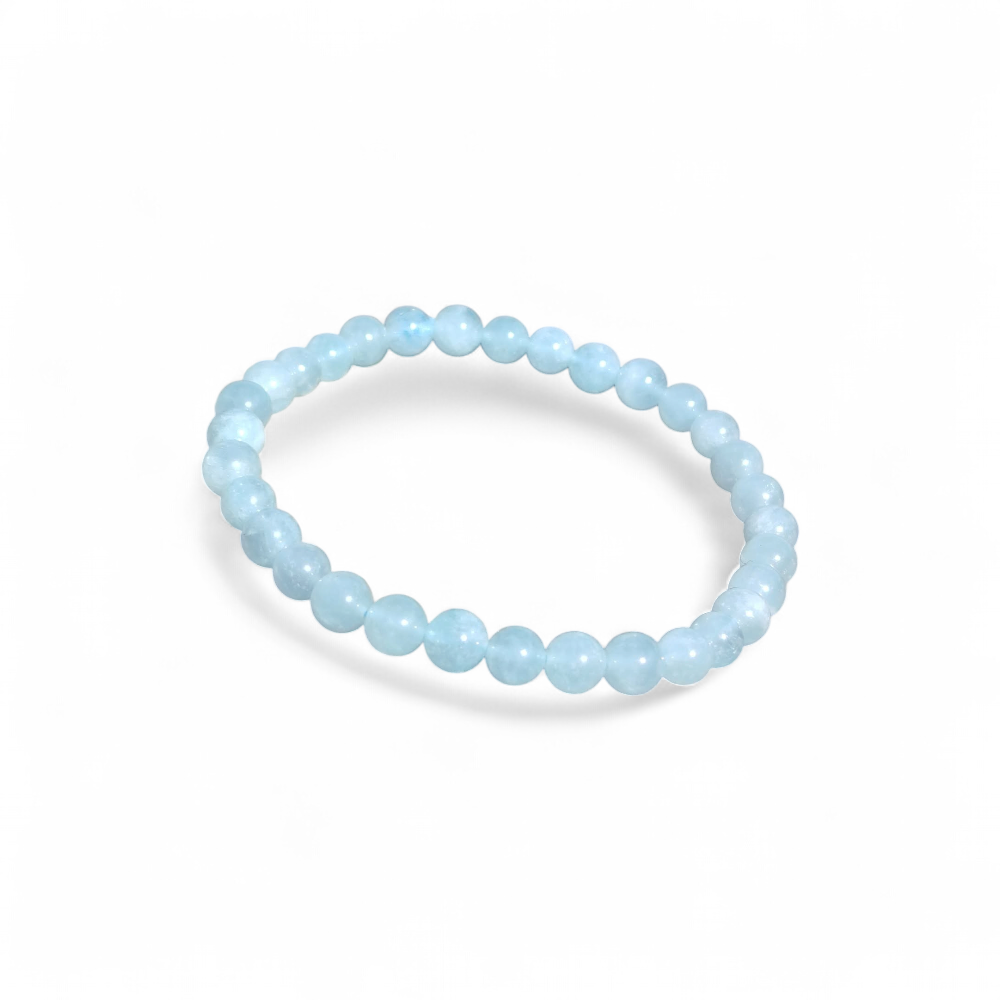 Bracelet Aigue-Marine 6 mm sur roche marine texturée, perles bleu ciel naturelles, sur fond blanc clarté émotionnelle et respiration plus paisible.