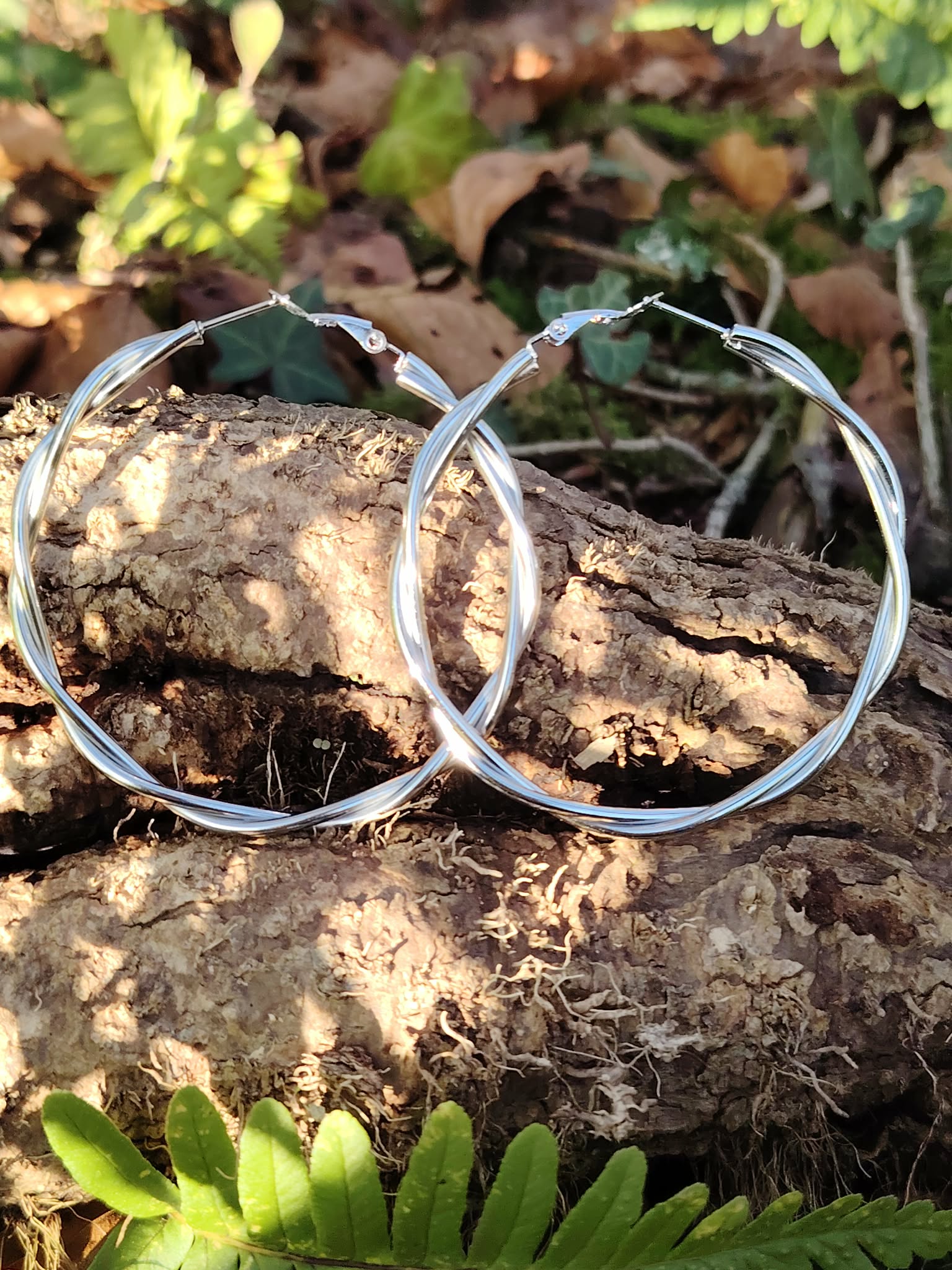 Boucles d’oreilles créoles argentées effet torsadé lisse en bord de rivière, acier inoxydable brillant au design élégant, style épuré et raffiné.