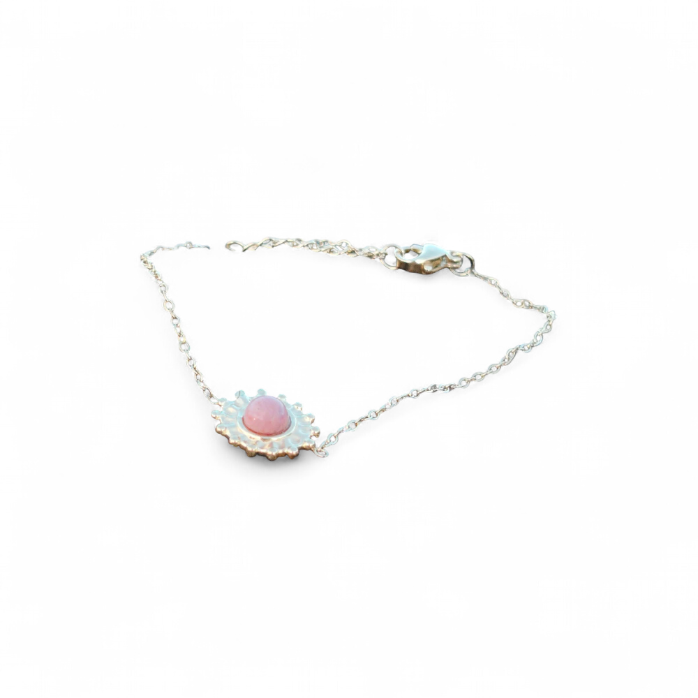 Bracelet soleil doré en acier inoxydable avec rhodonite rose sur fond blanc, motif solaire délicat et bijou fin féminin, harmonie intérieure et style raffiné.