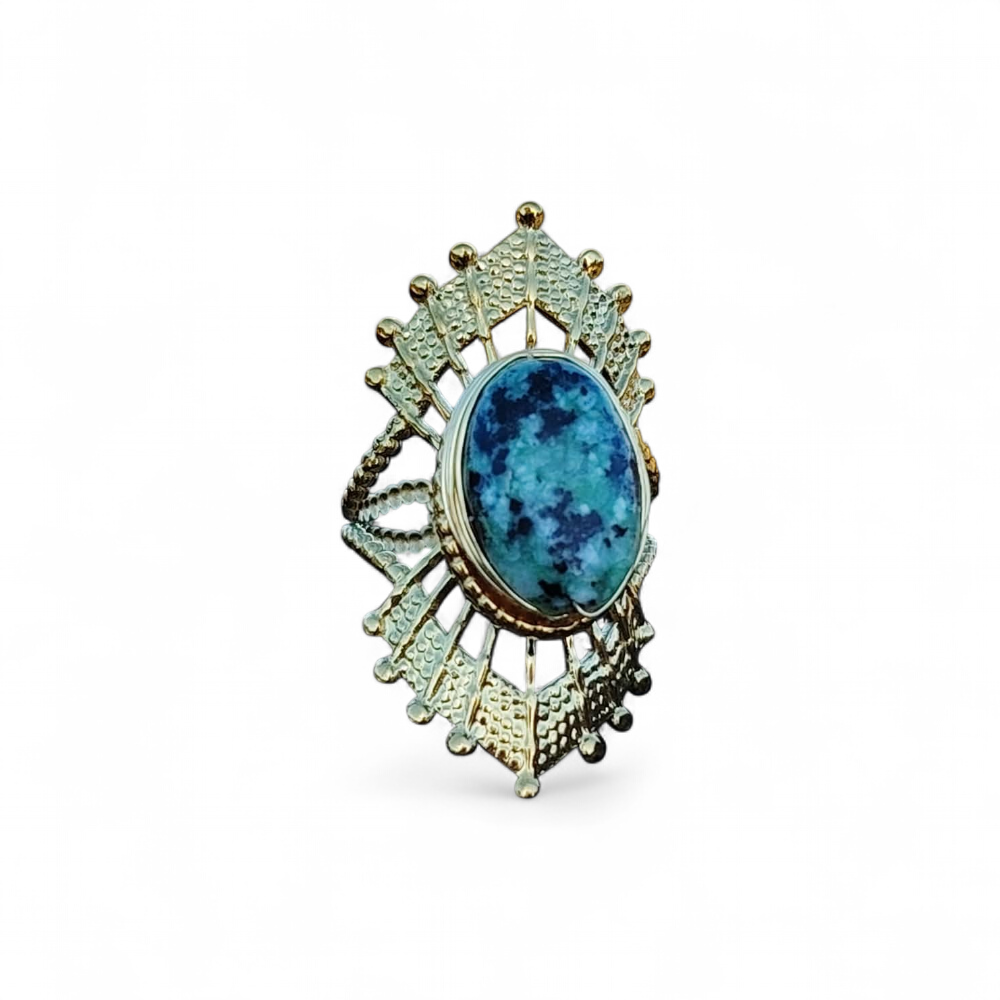 Bague solaire dorée ajustable en acier inoxydable sur fond blanc, pierre verte ovale marbrée et monture ajourée, raffinement lumineux et équilibre émotionnel.