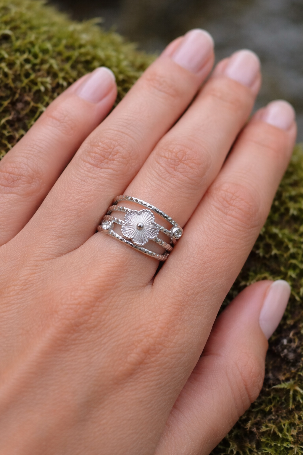 Bague fleur argentée ajustable avec strass sur écorce en forêt, acier inoxydable brillant et motif floral élégant, charme fin et féminin.