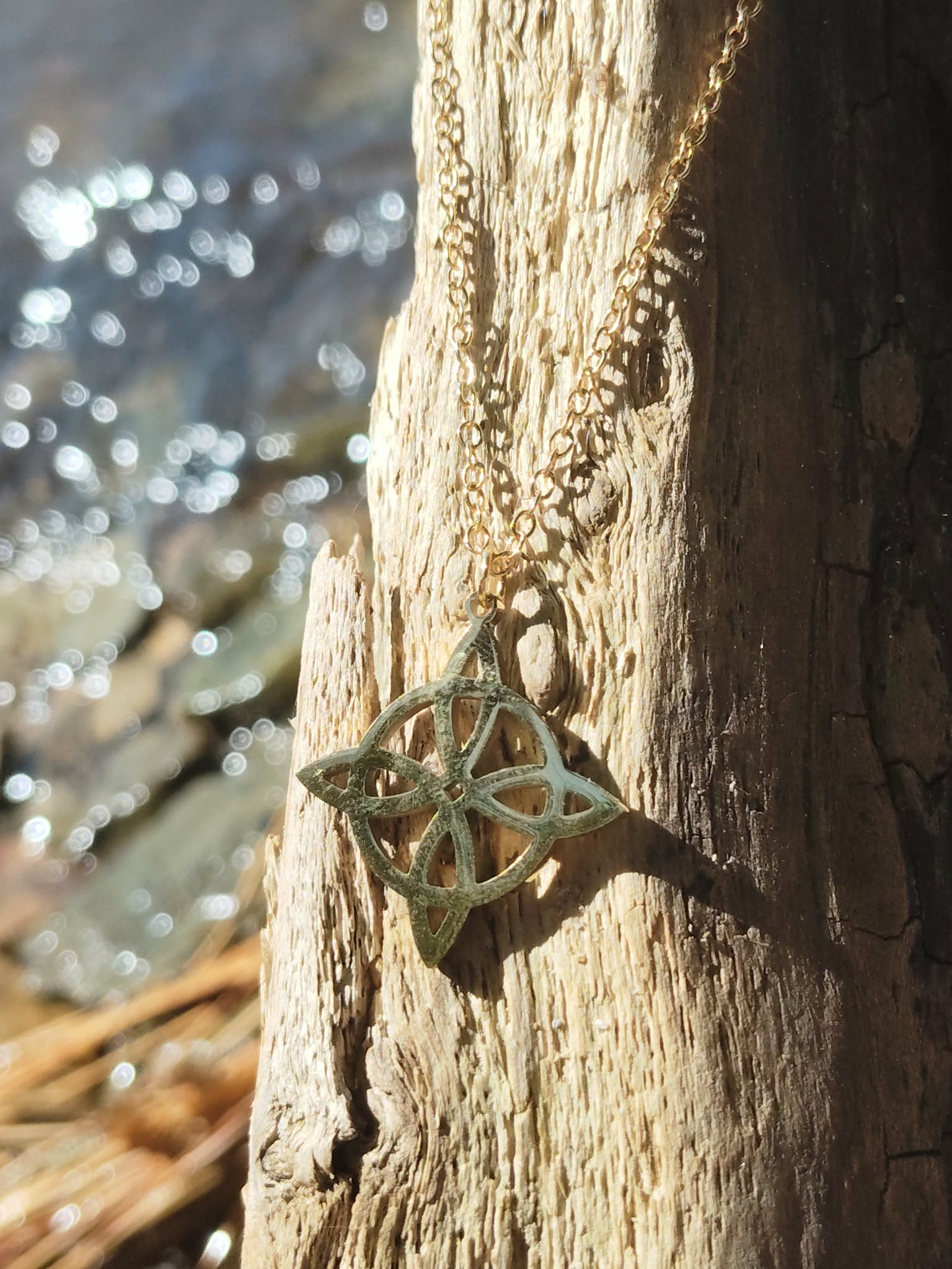 Pendentif nœud de sorcière en acier inoxydable doré présenté de près, symbole spirituel de défense énergétique et d’équilibre au quotidien.