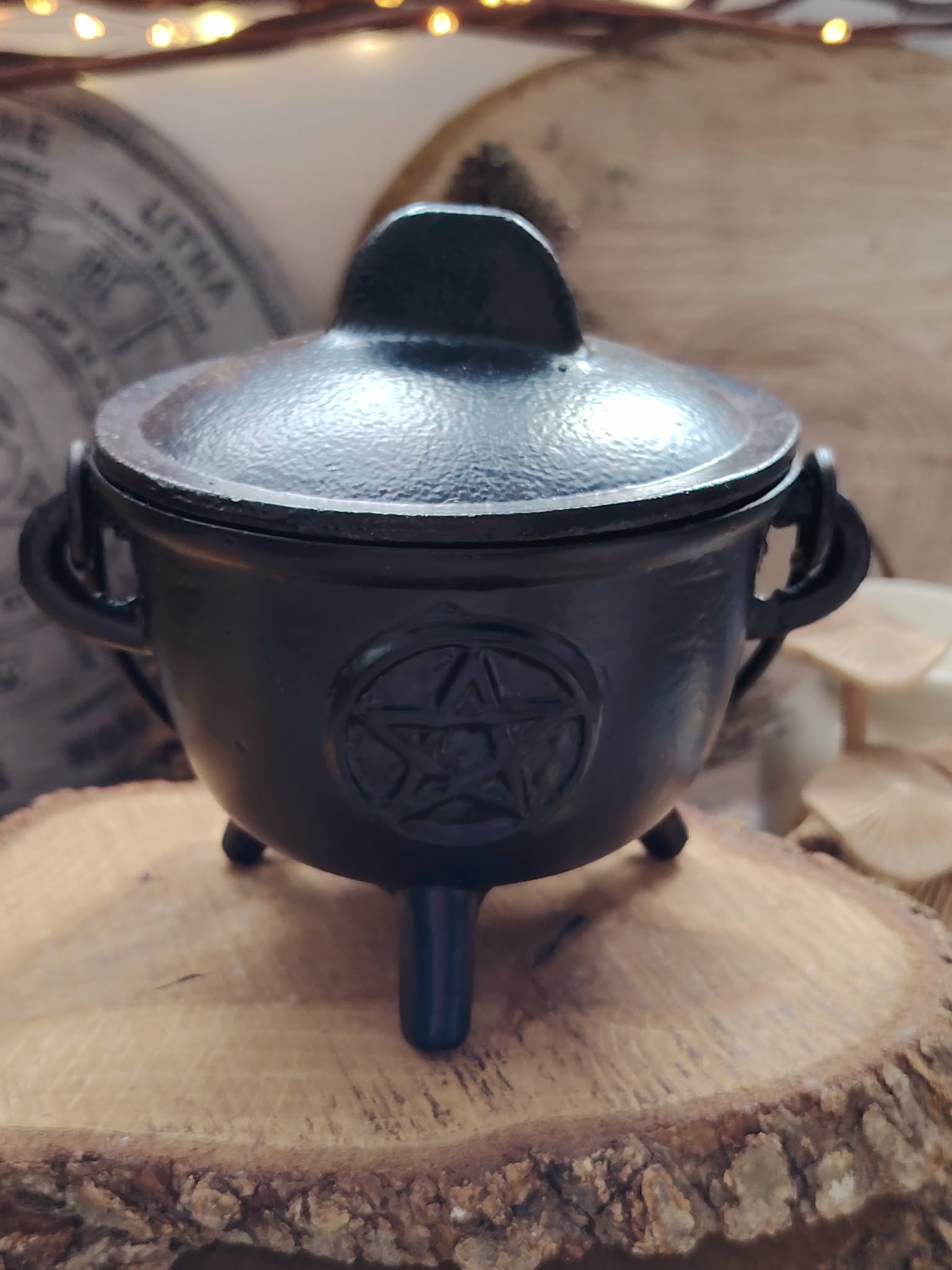 Chaudron en fonte noir avec pentacle gravé sur le couvercle, anse mobile et trois pieds, accessoire ésotérique pour autel et fumigation.
