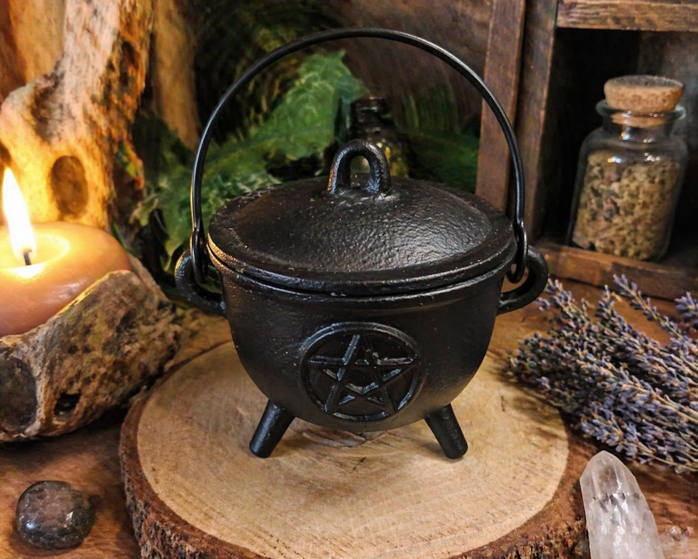 Chaudron en fonte pentacle avec couvercle sur rondin de bois, entouré de lavande, bougie et cristal dans une ambiance rituelle chaleureuse, protection symbolique et ancrage.