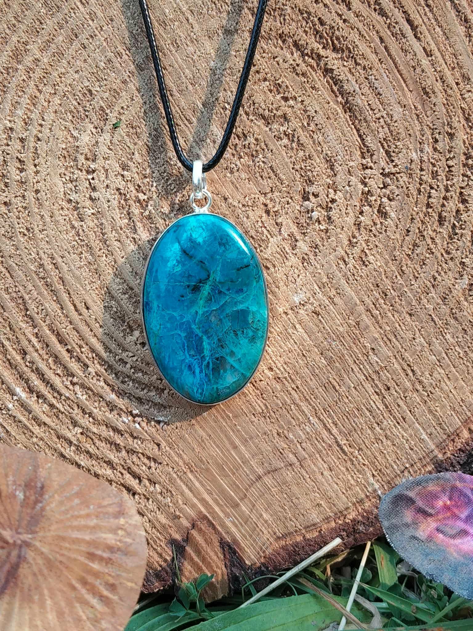 Pendentif chrysocolle argent 925 sur fond uni clair, cabochon ovale bleu intense sur cordon noir, pierre naturelle liée à l’apaisement et à l’écoute.
