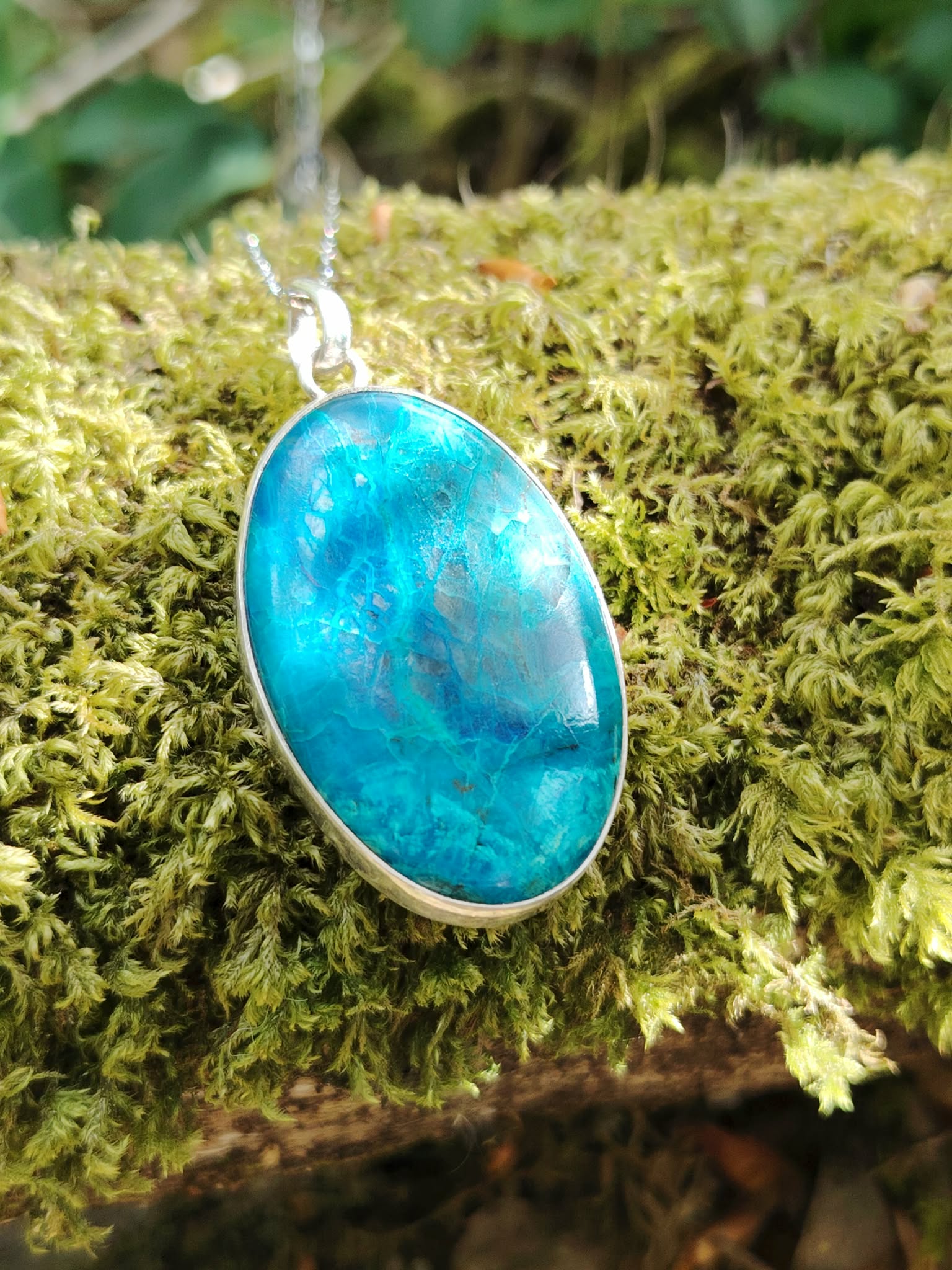Pendentif chrysocolle argent 925 en gros plan sur mousse verte, pierre bleu vert naturelle montée sur chaîne, apaisement mental et stabilité émotionnelle.
