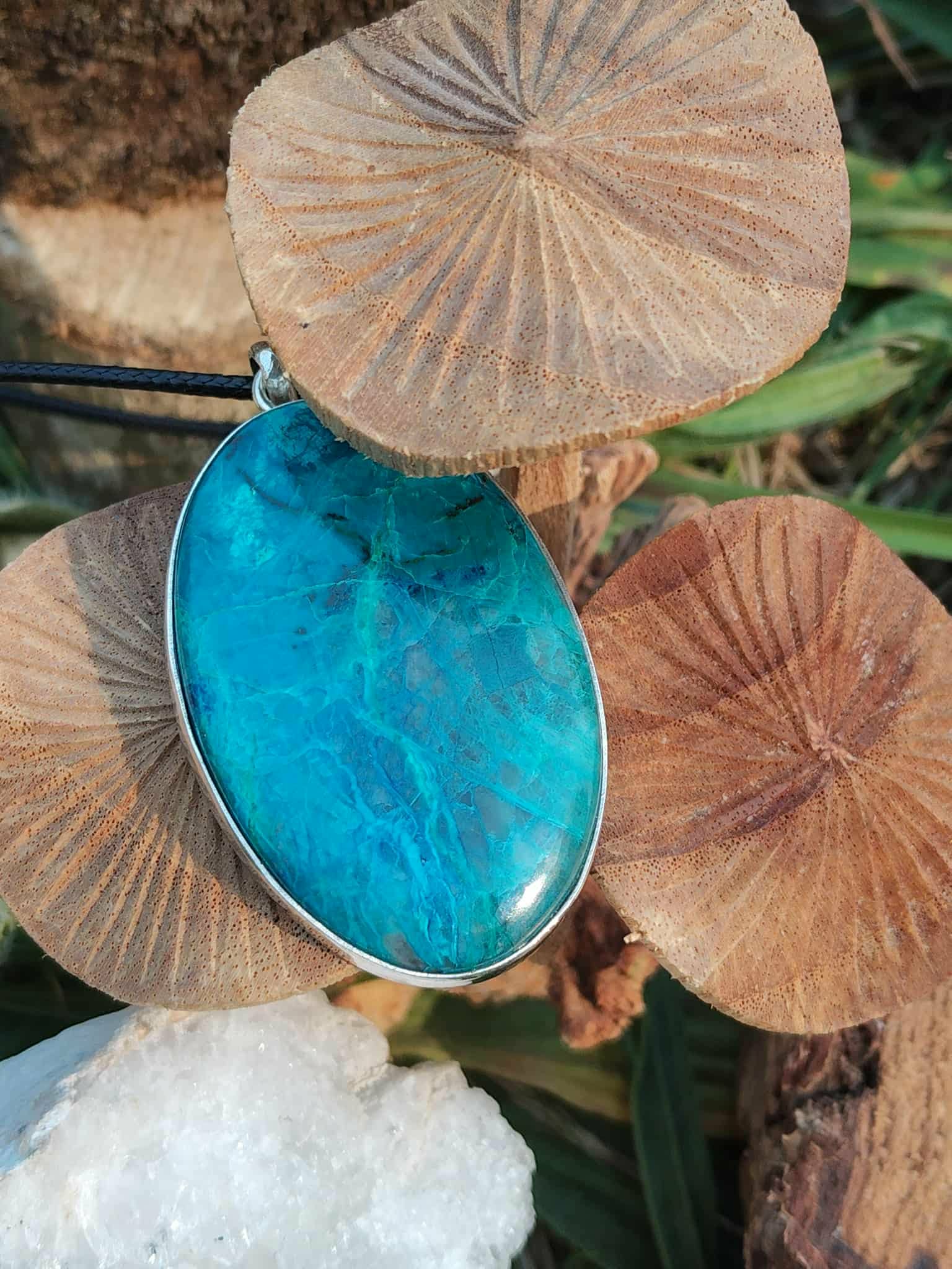 Pendentif chrysocolle argent 925 posé parmi des champignons et un amas de quartz  blanc, pierre ovale bleu lagon, calme émotionnel et communication fluide.