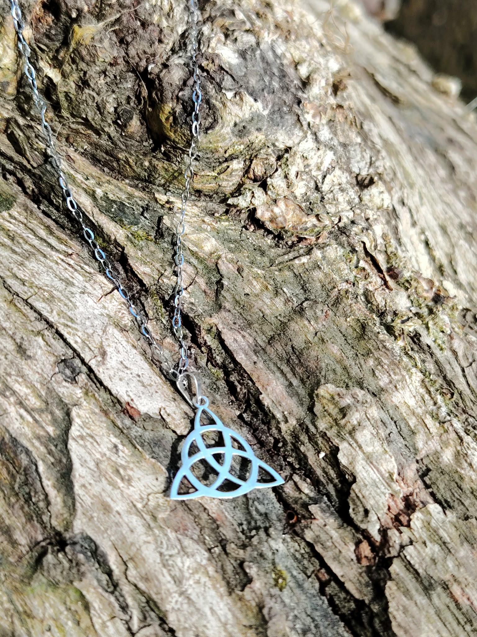 Pendentif Triquetra argent 925 photographié en gros plan, bijou celtique ajouré aux courbes fines, recentrage, solidité intérieure et élévation.