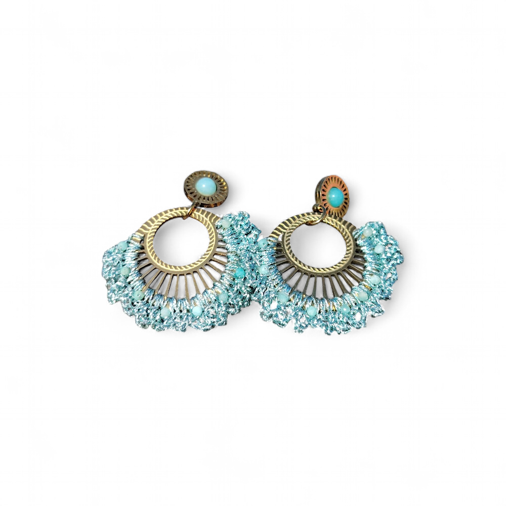 Boucles d’oreilles pendantes dorées avec cabochon bleu turquoise sur fond uni clair, style éventail tressé bohème chic