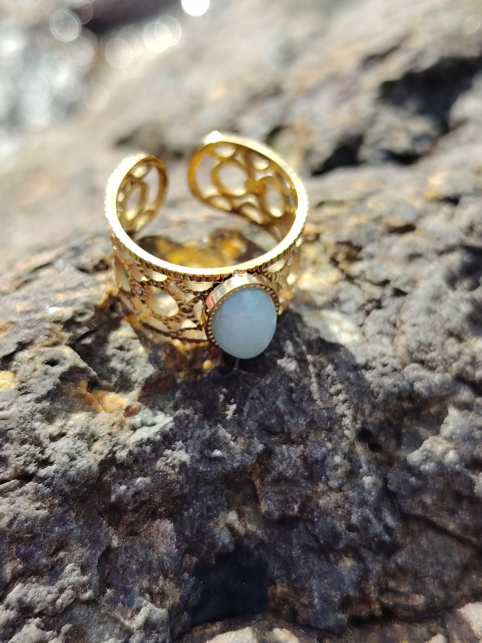 Bague réglable Amazonite sur décor marin breton, acier inoxydable doré ajouré, bijou lumineux lié à l’équilibre émotionnel.