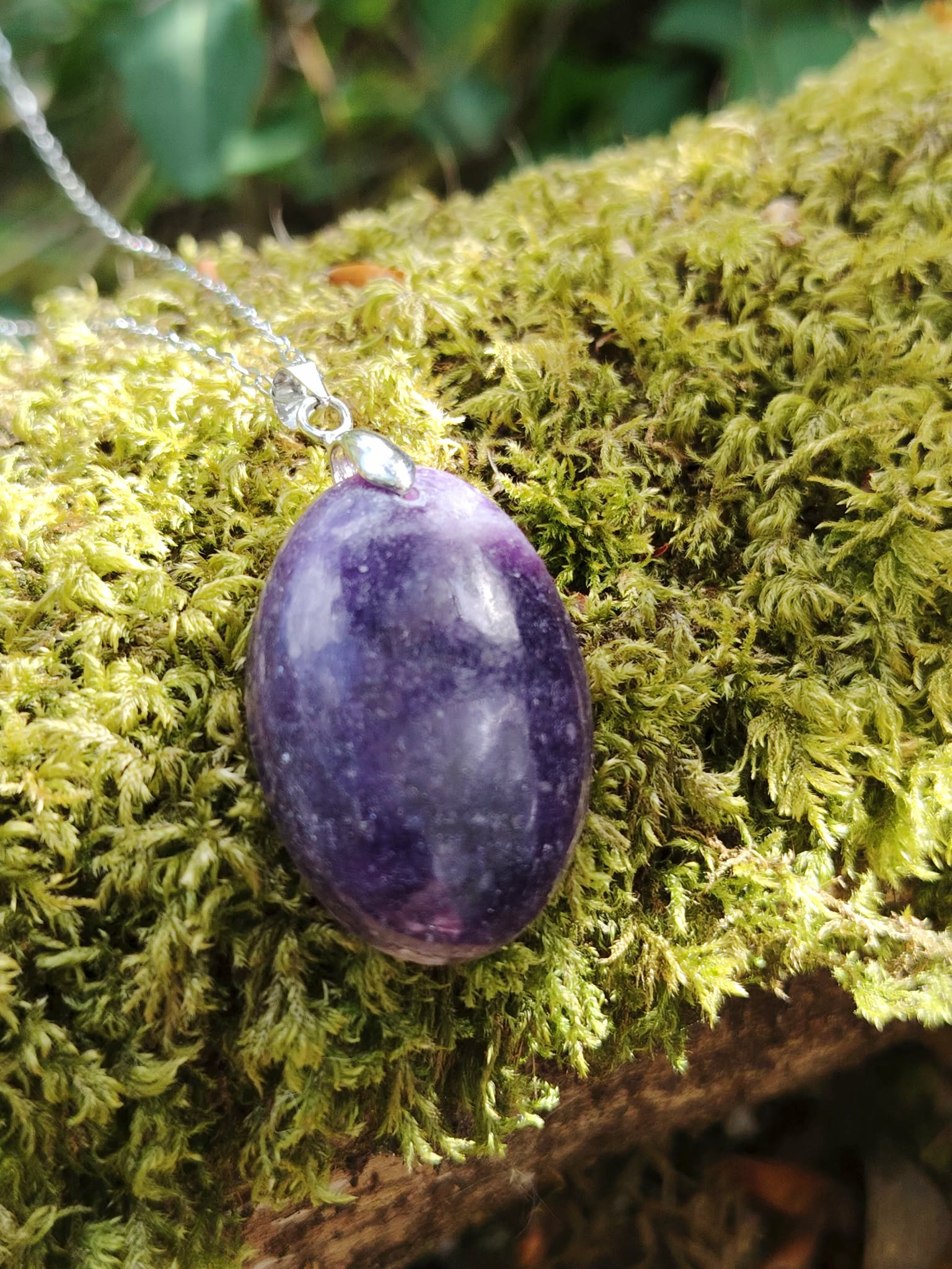 Pendentif Lépidolite violette sur mousse verte en lumière naturelle en Bretagne, pierre apaisante liée au sommeil et au relâchement mental
