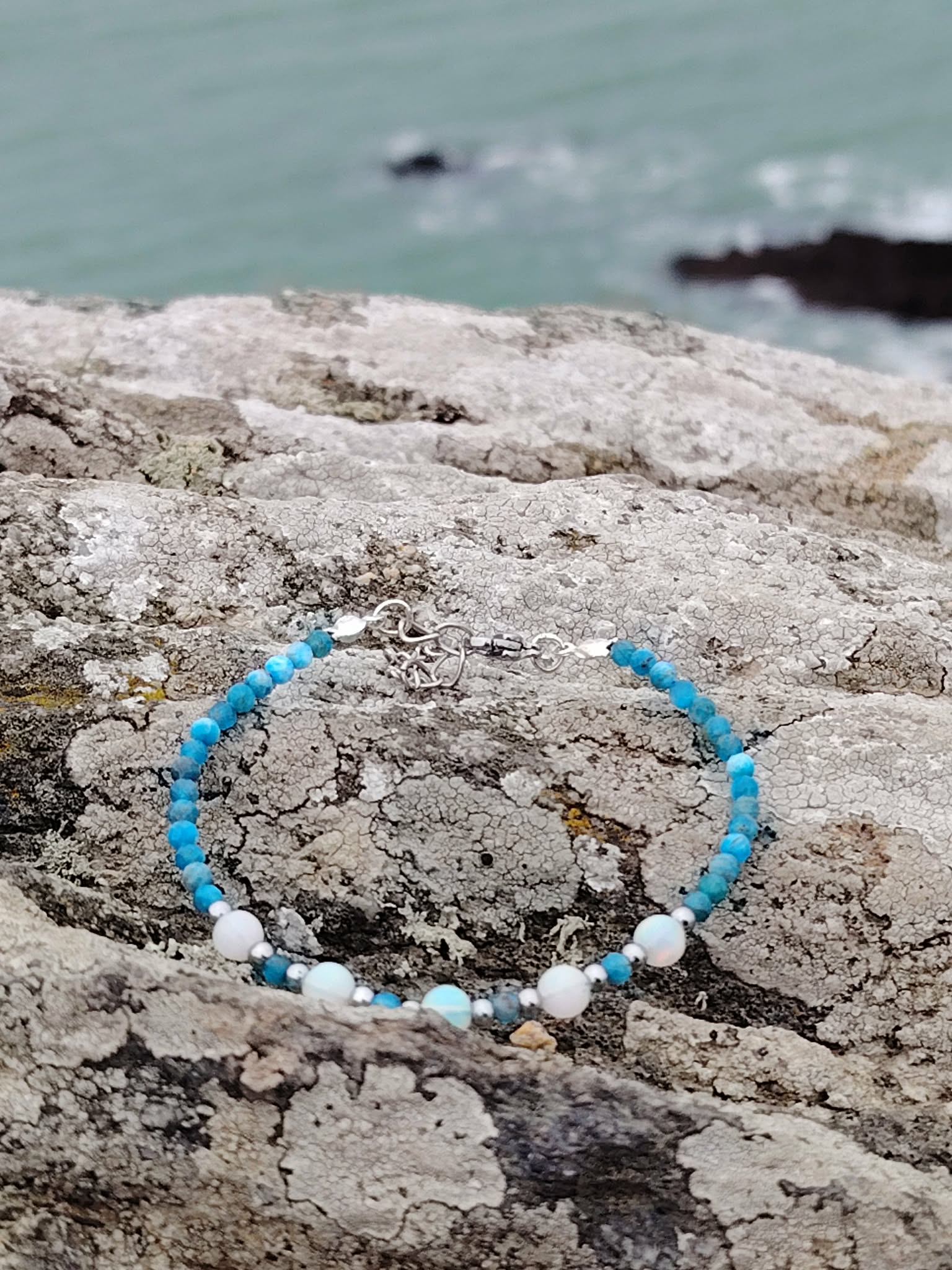 Gros plan sur bracelet création Magic Gaïa en apatite facettée et opale, perles bleues éclatantes, opale douce et créativité.