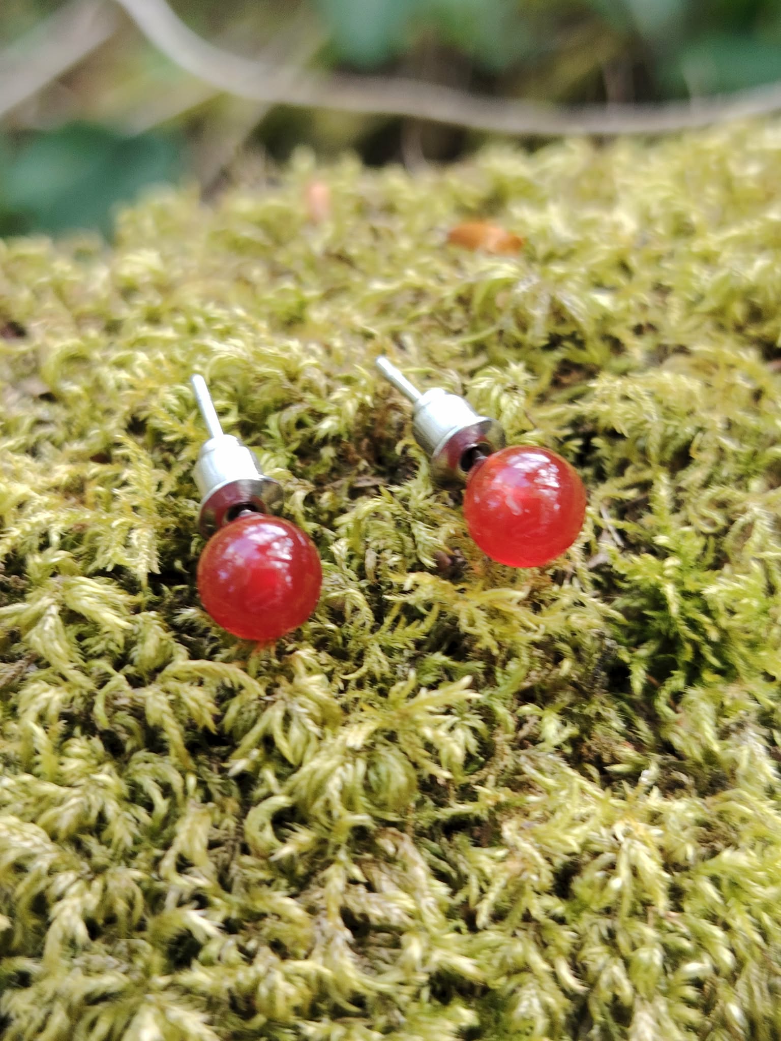 Puces Cornaline en acier inoxydable 304 photographiées en Bretagne, perles rouges chaleureuses, motivation et élan créatif.
