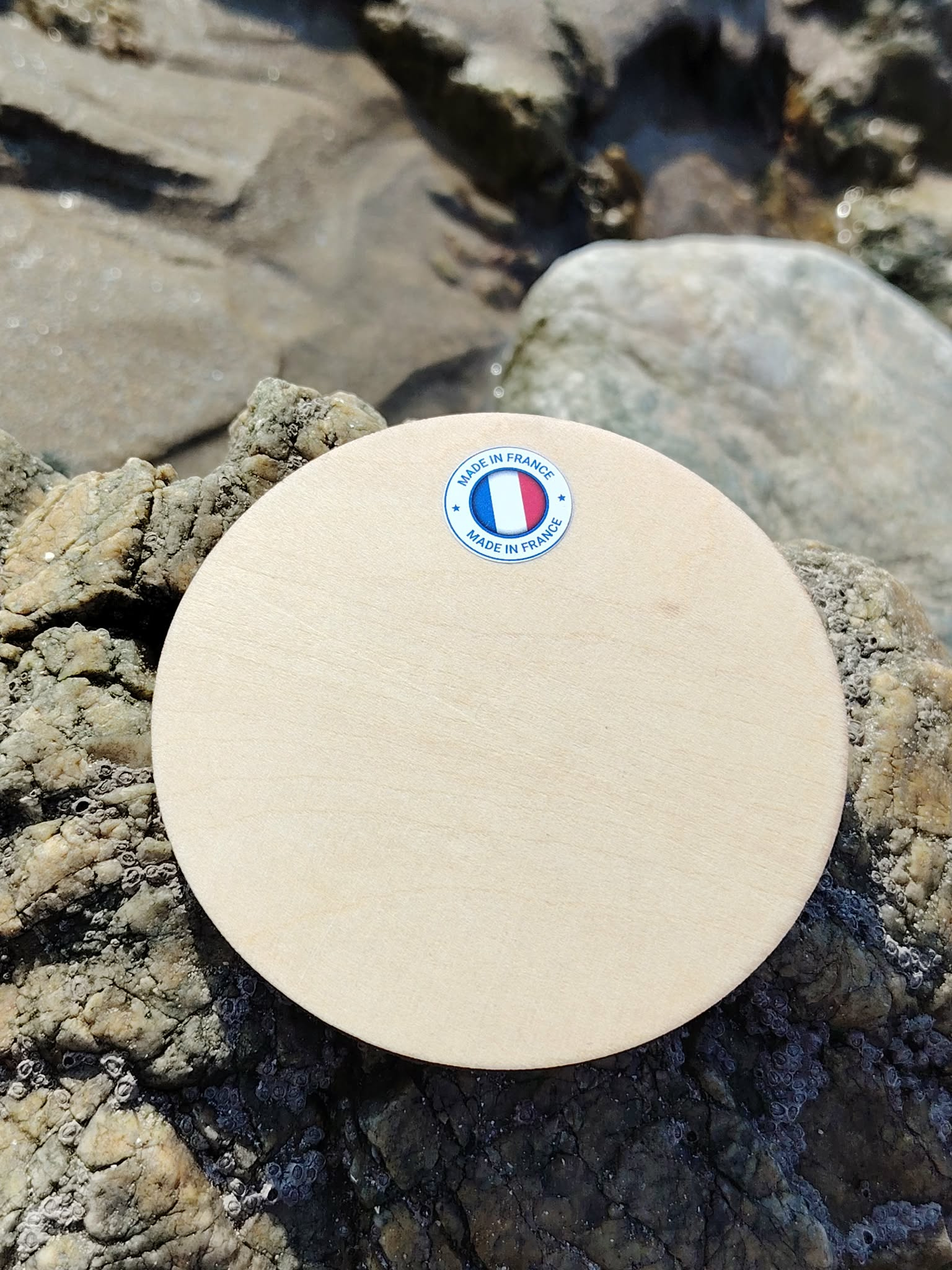 Verso de la plaque Triskell en bois de tilleul sur rochers bretons, fabrication française et finition naturelle.