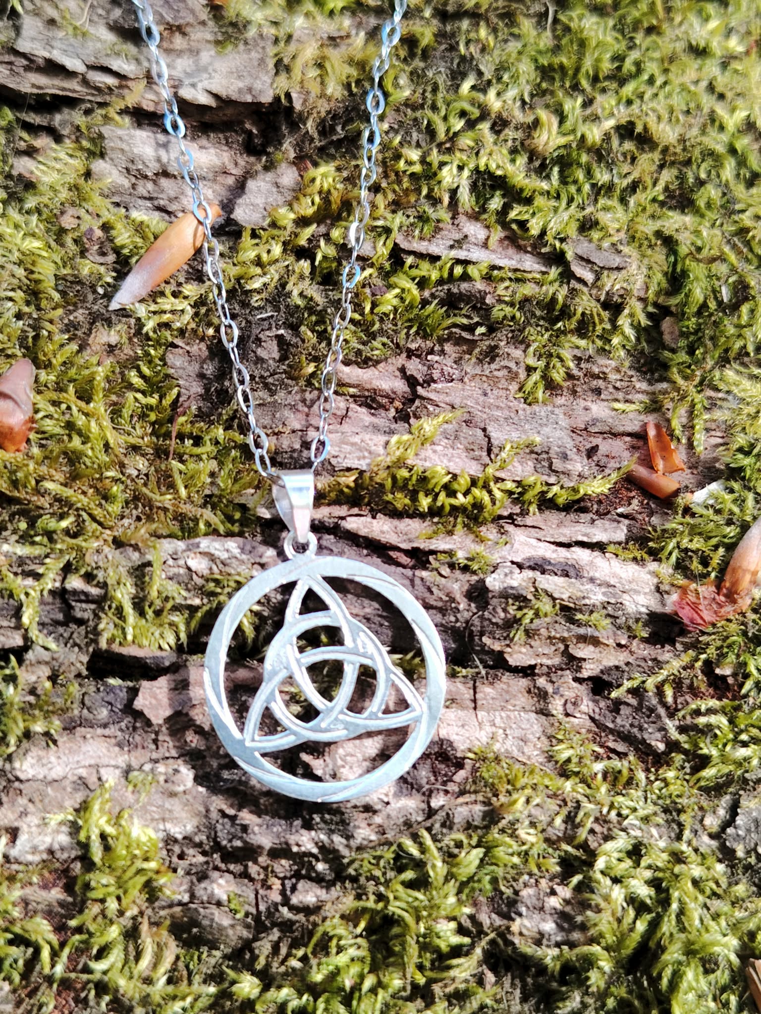 Pendentif Triquetra rond en argent 925 en décor naturel breton, médaillon celtique ajouré au style sobre et lumineux.