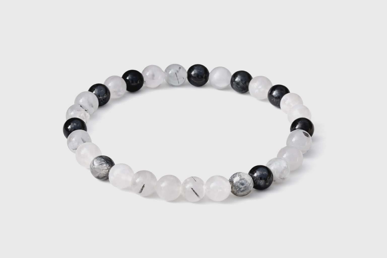 Bracelet Tourmaline noire et Quartz tourmaliné sur fond blanc, perles 6 mm noires et blanches pour clarté intérieure et équilibre.