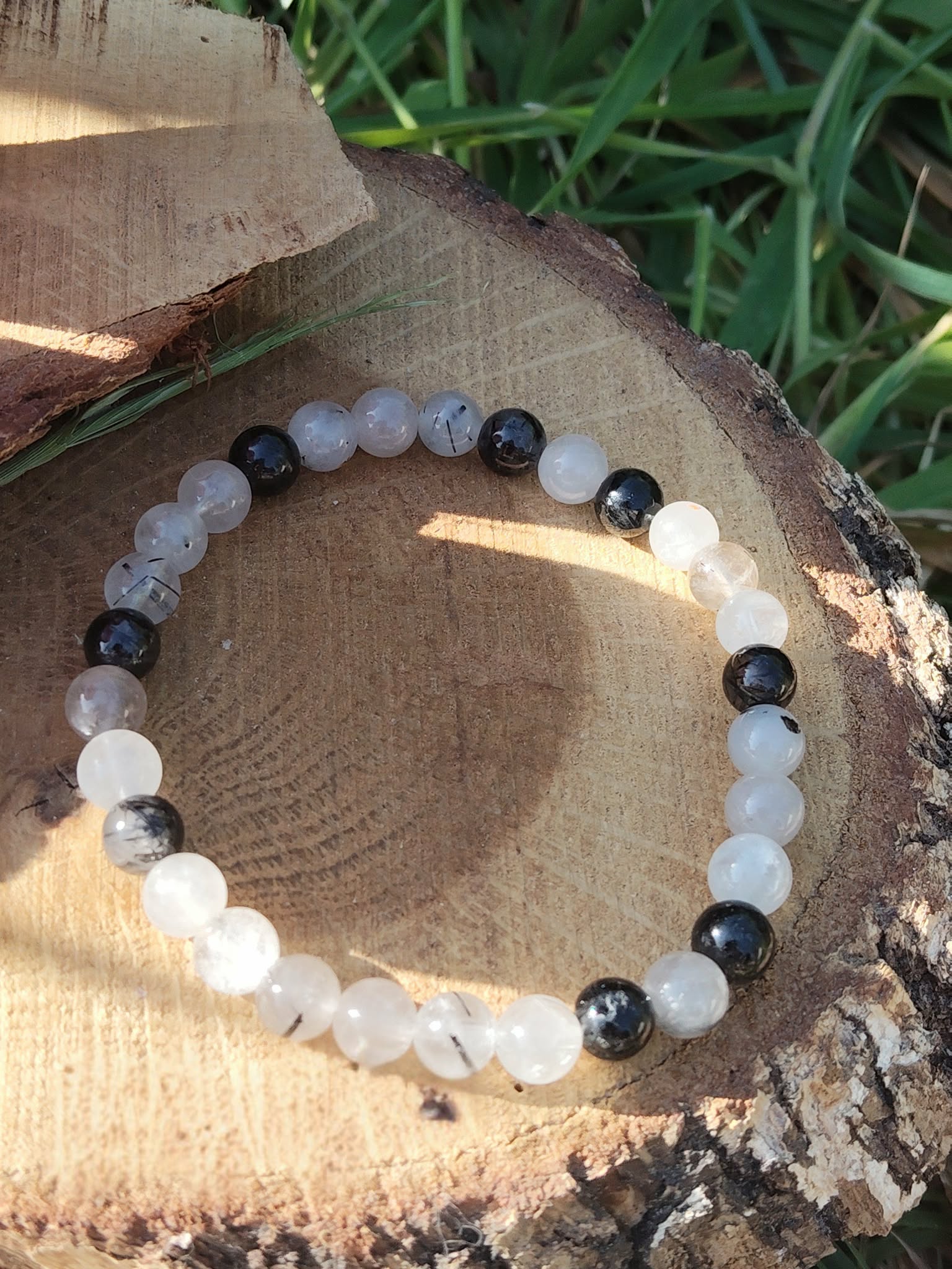 Bracelet Tourmaline noire et Quartz tourmaliné sur bois naturel au soleil, bijou 6 mm pour équilibre émotionnel et force intérieure.