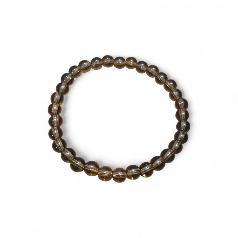 Gros plan sur bracelet Quartz fumé 6 mm sur fond blanc, perles rondes brun clair à brun profond, bijou sobre associé à l’équilibre.