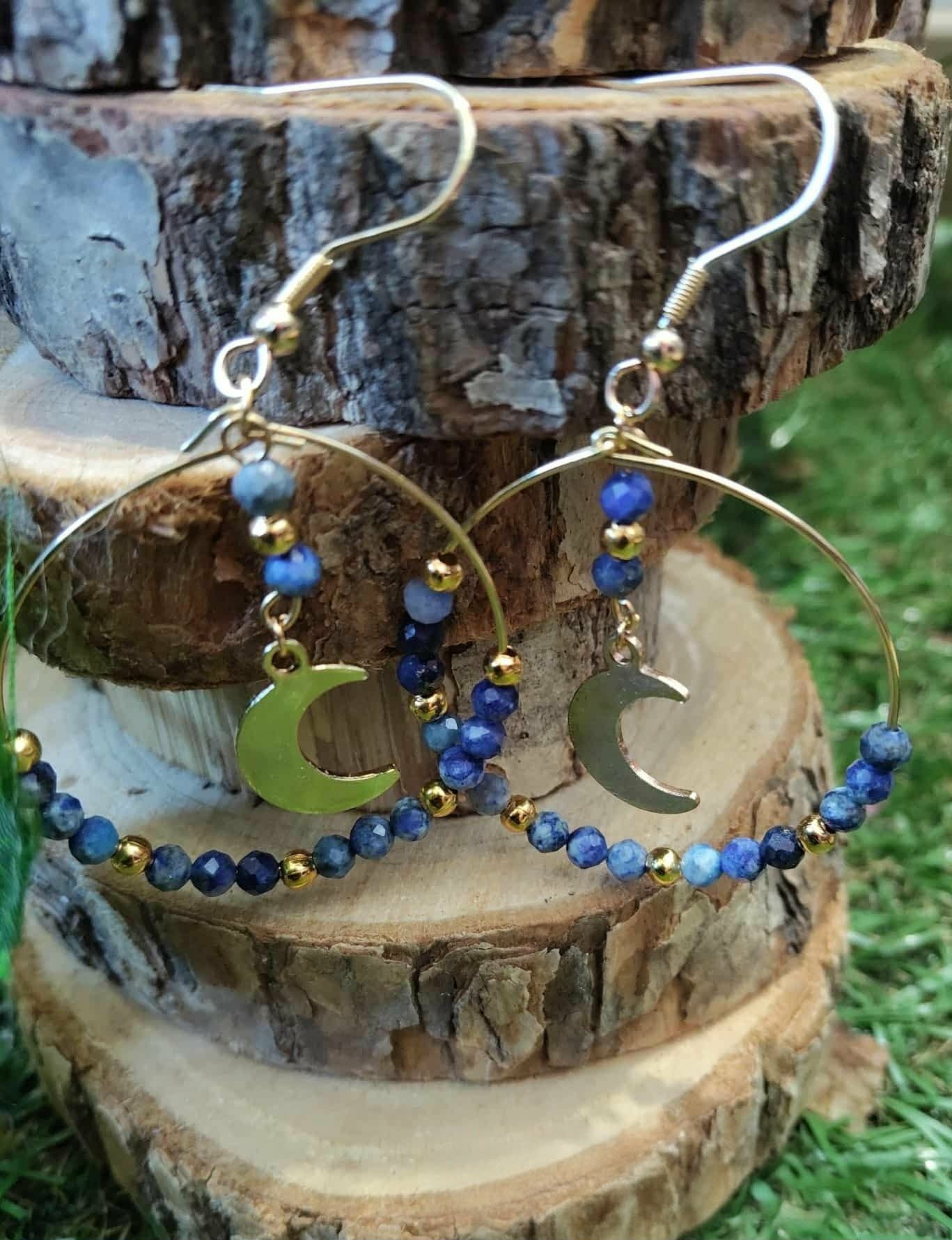 Créoles pendantes dorées en lapis lazuli facetté, détails bleus profonds et lune centrale pour sagesse et équilibre énergétique.