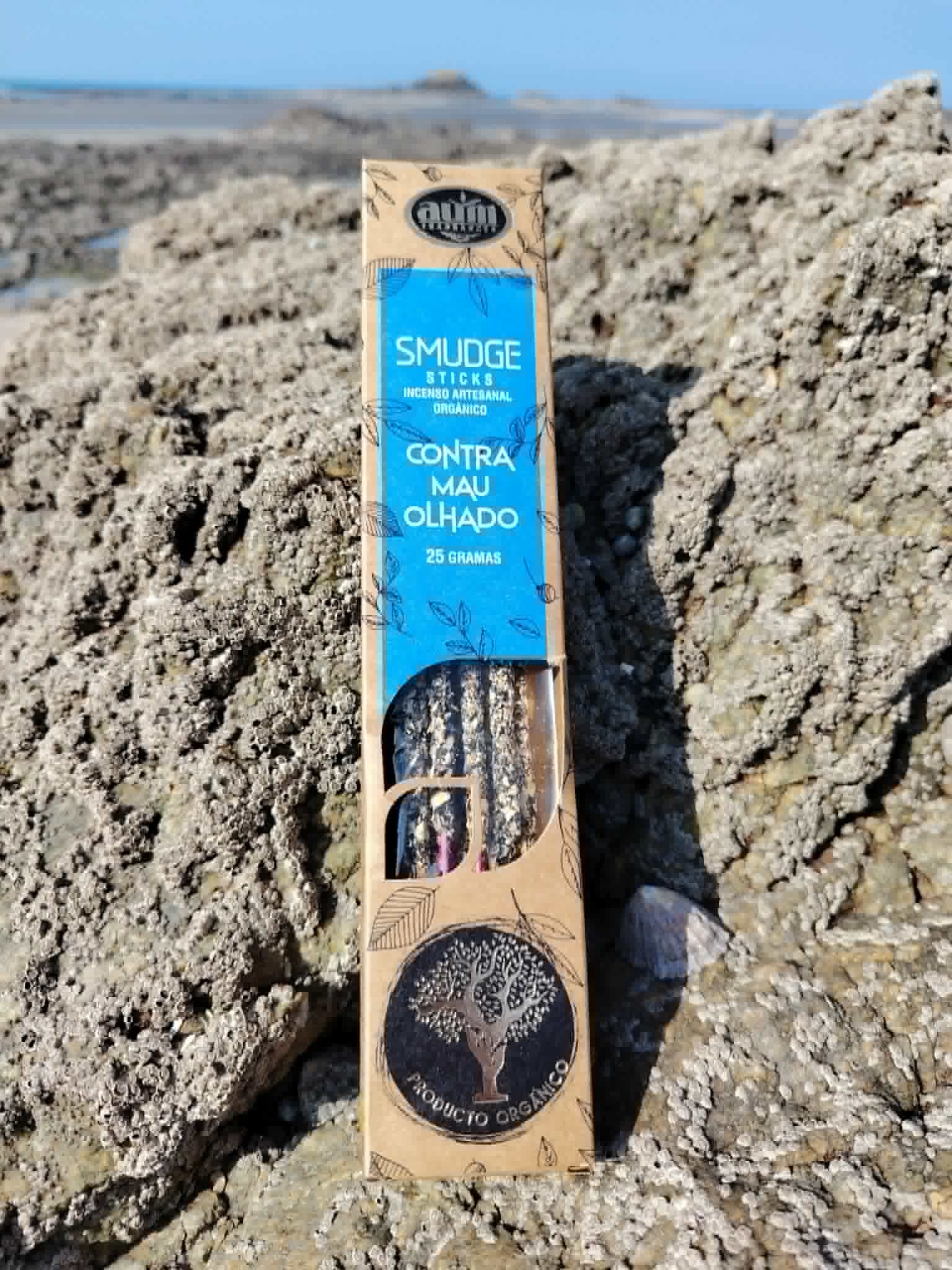 Encens AUM Organico Contre le Mauvais Œil 25 g posé sur rocher en bord de mer breton, ambiance rituelle naturelle.