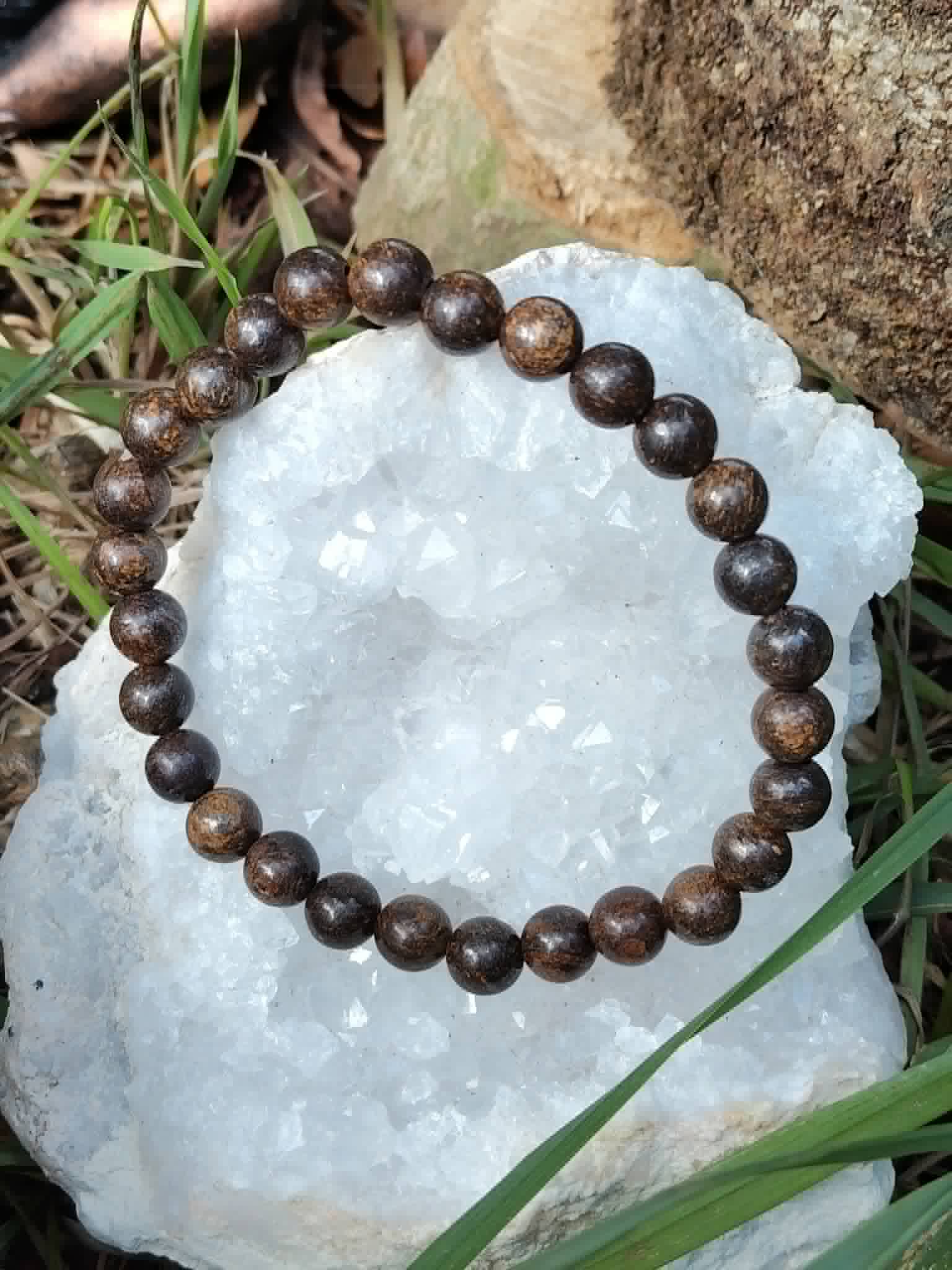 Bracelet en pierre bronzite posé dans une ambiance minérale, reflets bruns métallisés pour stabilité intérieure et maîtrise de soi.