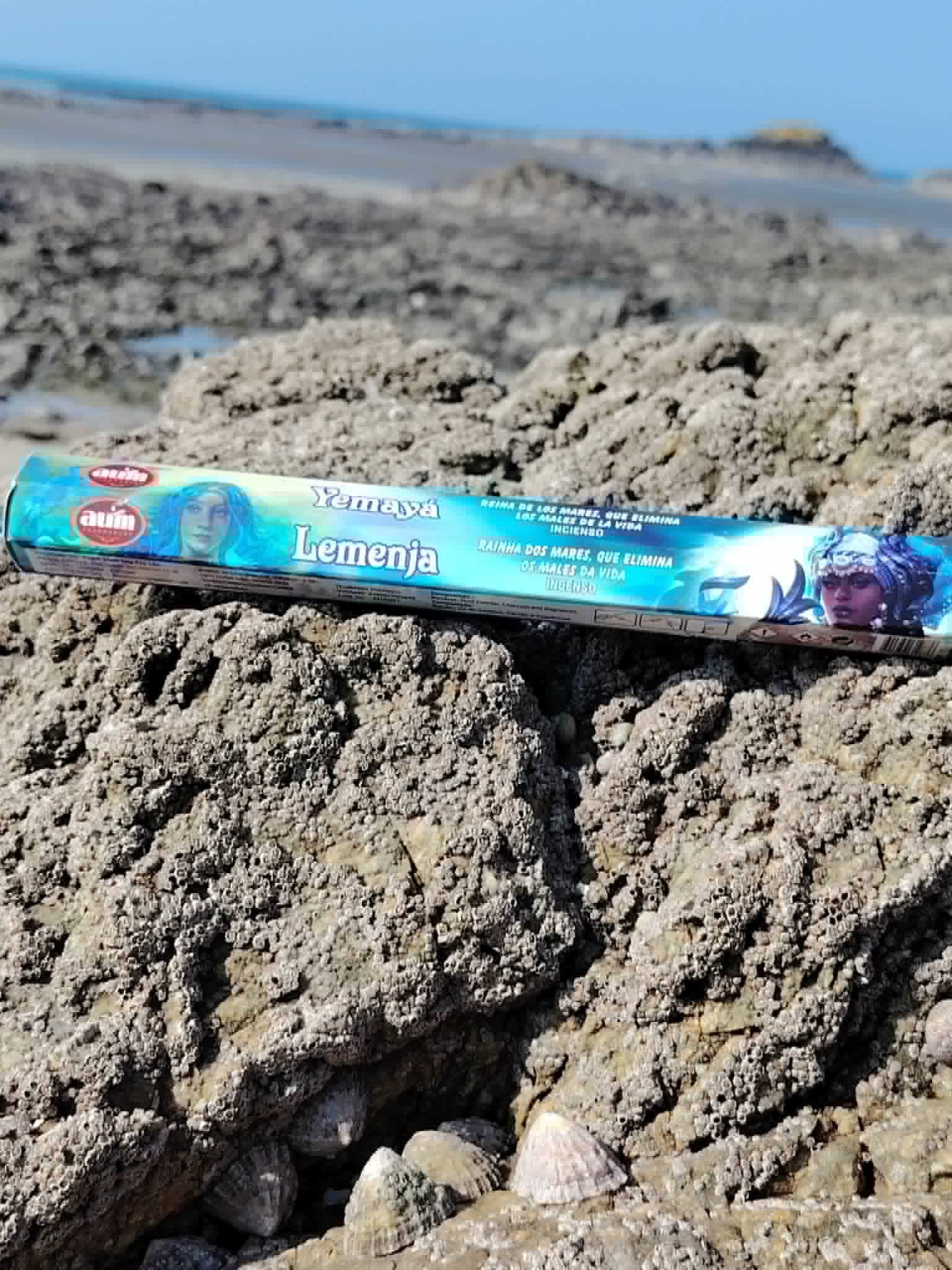 Encens AUM Yemayá Iemanjá posé sur rocher en bord de mer breton, support rituel lié aux eaux et au calme.