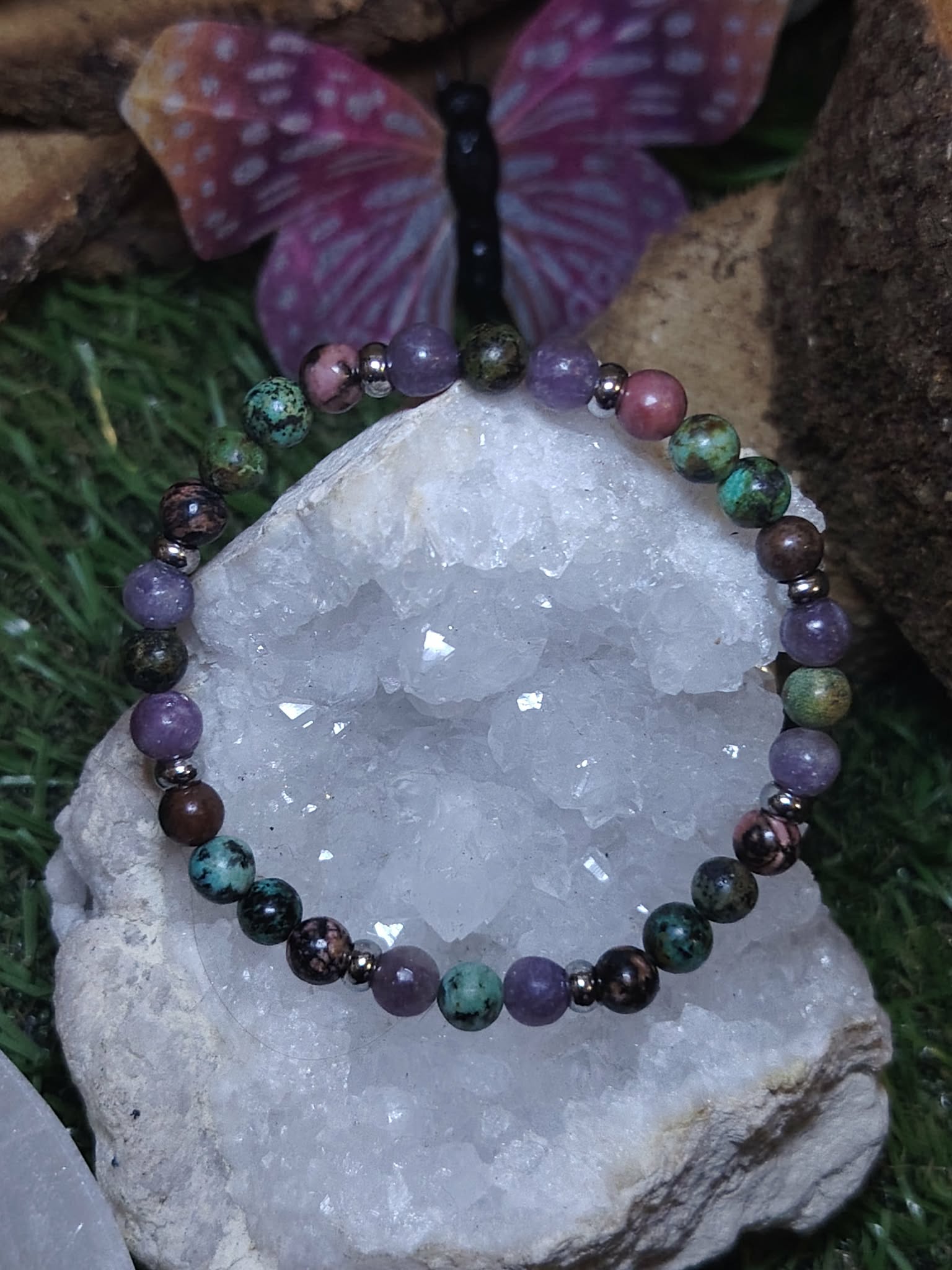 Bracelet équilibre émotionnel posé sur amas de quartz, perles 6 mm colorées pour apaisement du cœur et harmonie intérieure.