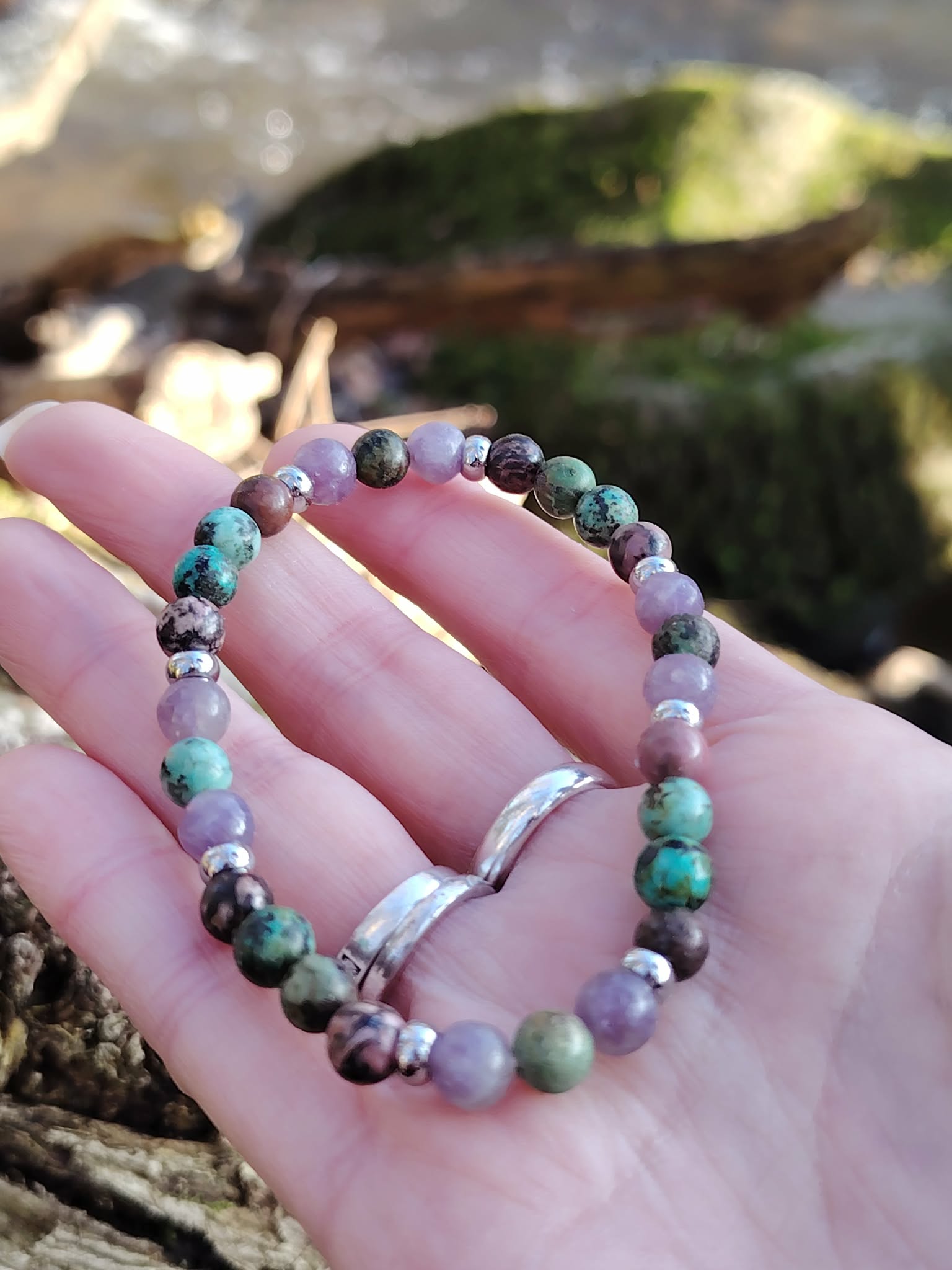 Bracelet équilibre émotionnel tenu en main dans un décor naturel, perles 6 mm pour apaisement du cœur et harmonie intérieure.
