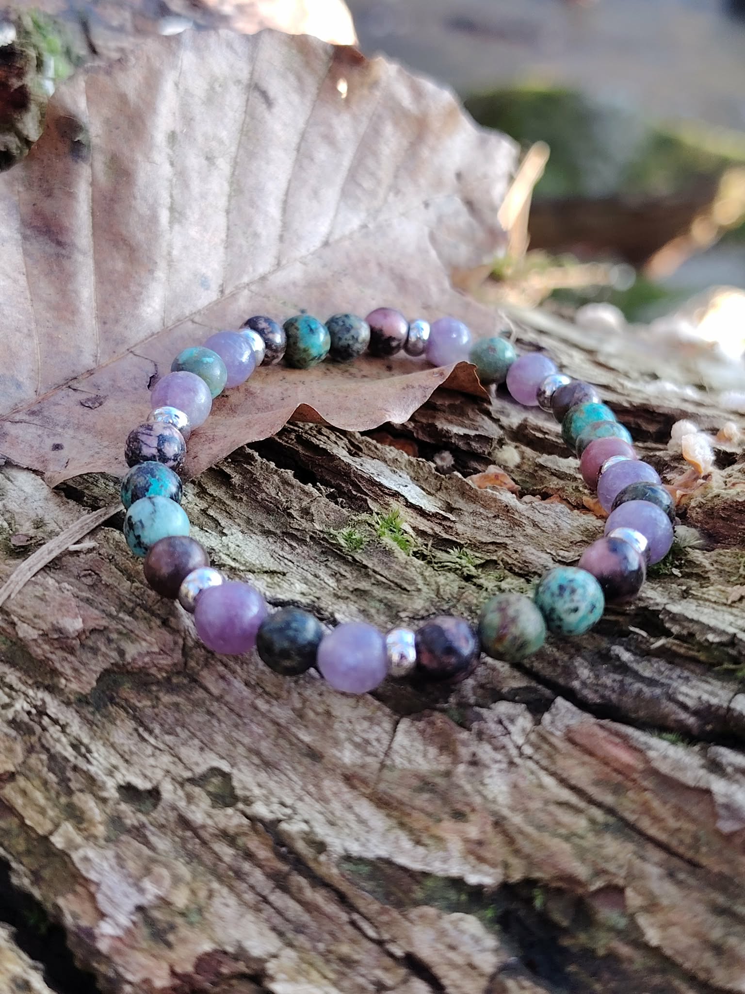 Bracelet équilibre émotionnel posé sur bois, pierres naturelles colorées pour harmonie du cœur, expression plus fluide et sérénité.